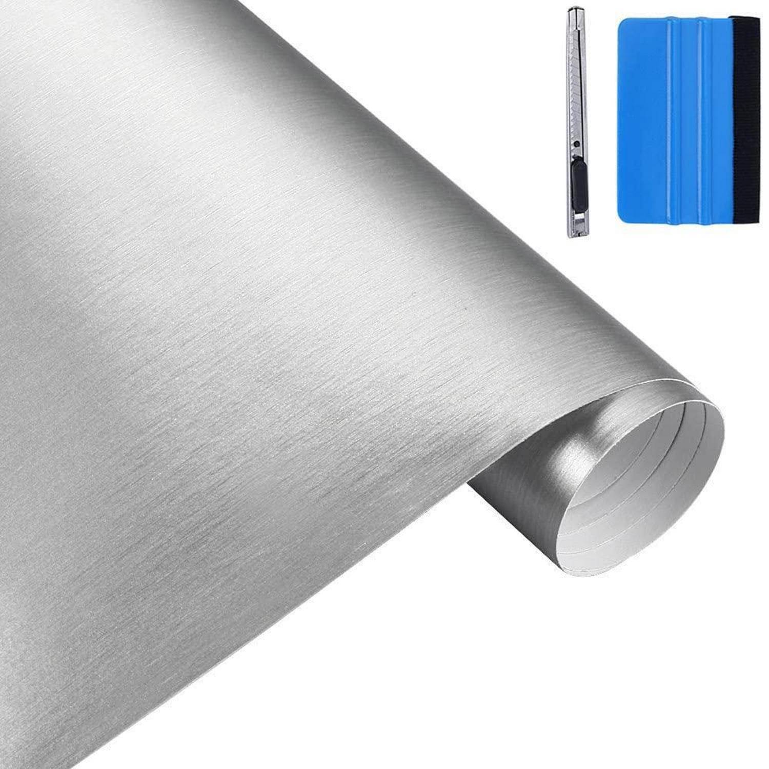 Rolle aus gebürstetem Silber-Haftvinyfilm mit einem blauen Rakel und Universalmesser zur Anwendung.