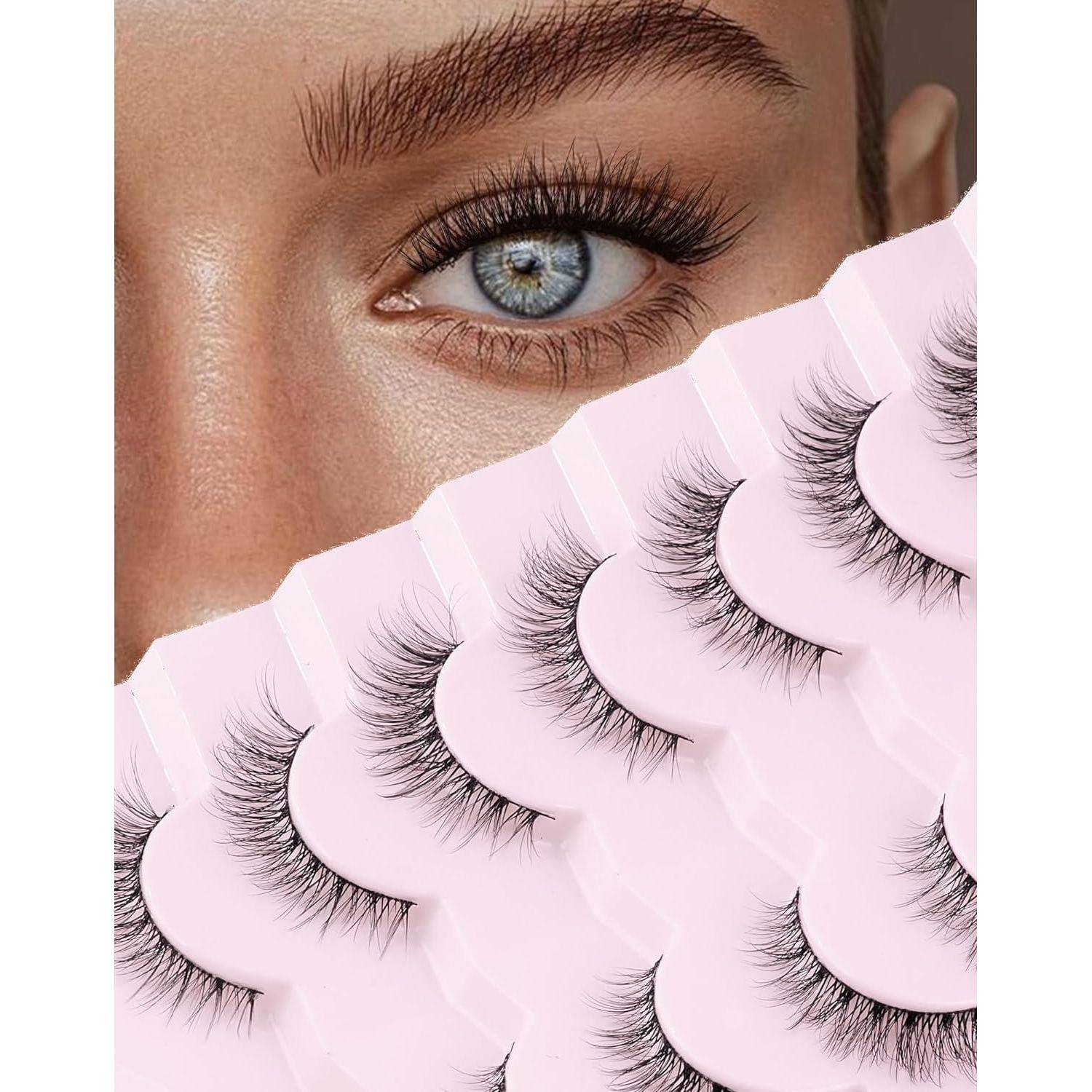 Nahaufnahme eines Frauenauges und einer Augenbraue mit einem Fächer von künstlichen Wimpern in rosa Verpackung, was auf Wimpernverlängerung oder Schönheitsproduktbewerbung hindeutet.