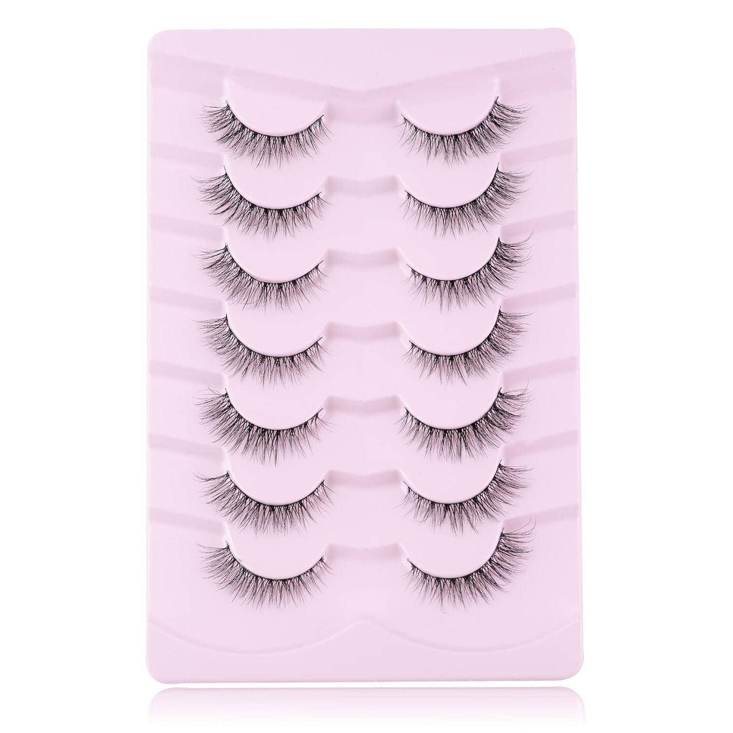 Sechs Paar künstliche Wimpern auf einem rosa Präsentationstablett angeordnet