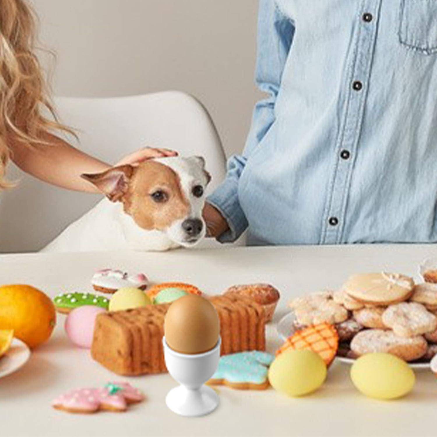 Hund und zwei Personen an einem Tisch mit verschiedenen Gebäckstücken und verzierten Ostereiern, was auf eine festliche Frühstücks- oder Dessertszene hindeutet.