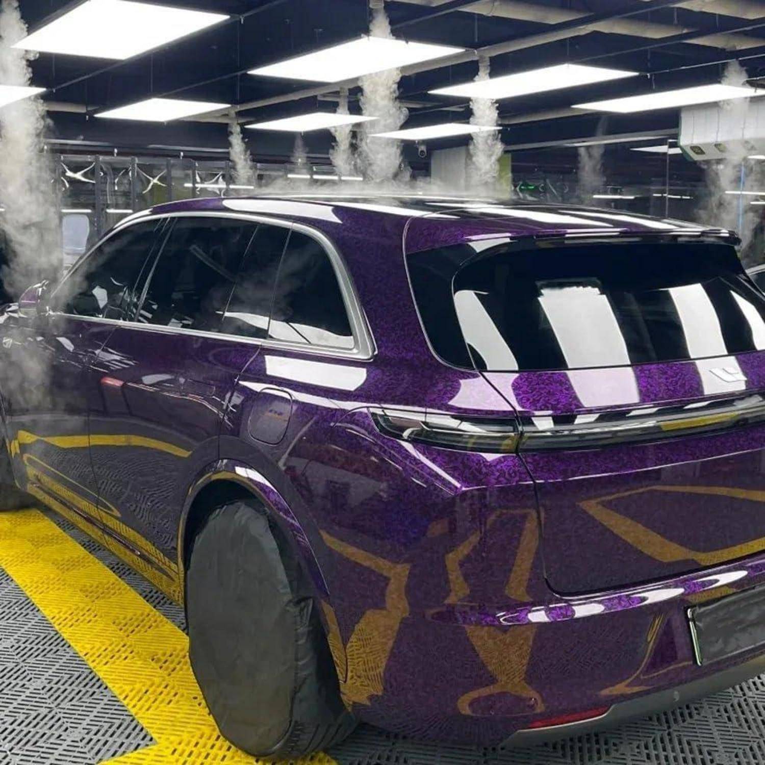 Violetter SUV in einer Indoor-Detailing-Kabine, mit einer Schutzfolie oder Beschichtung mit glänzendem Finish bedeckt.