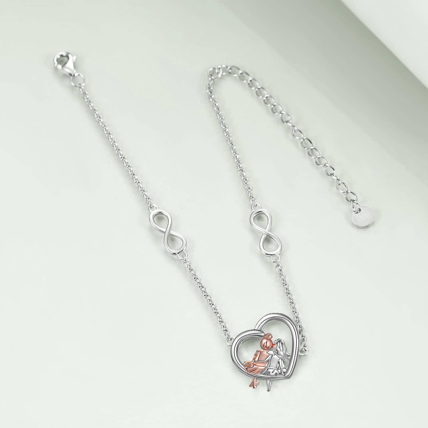 Silbernes Herzanhänger-Halskette mit Unendlichkeitssymbolen und einem baumelnden Charm einer sitzenden Figur in Roségold an einer Kettenverlängerung.