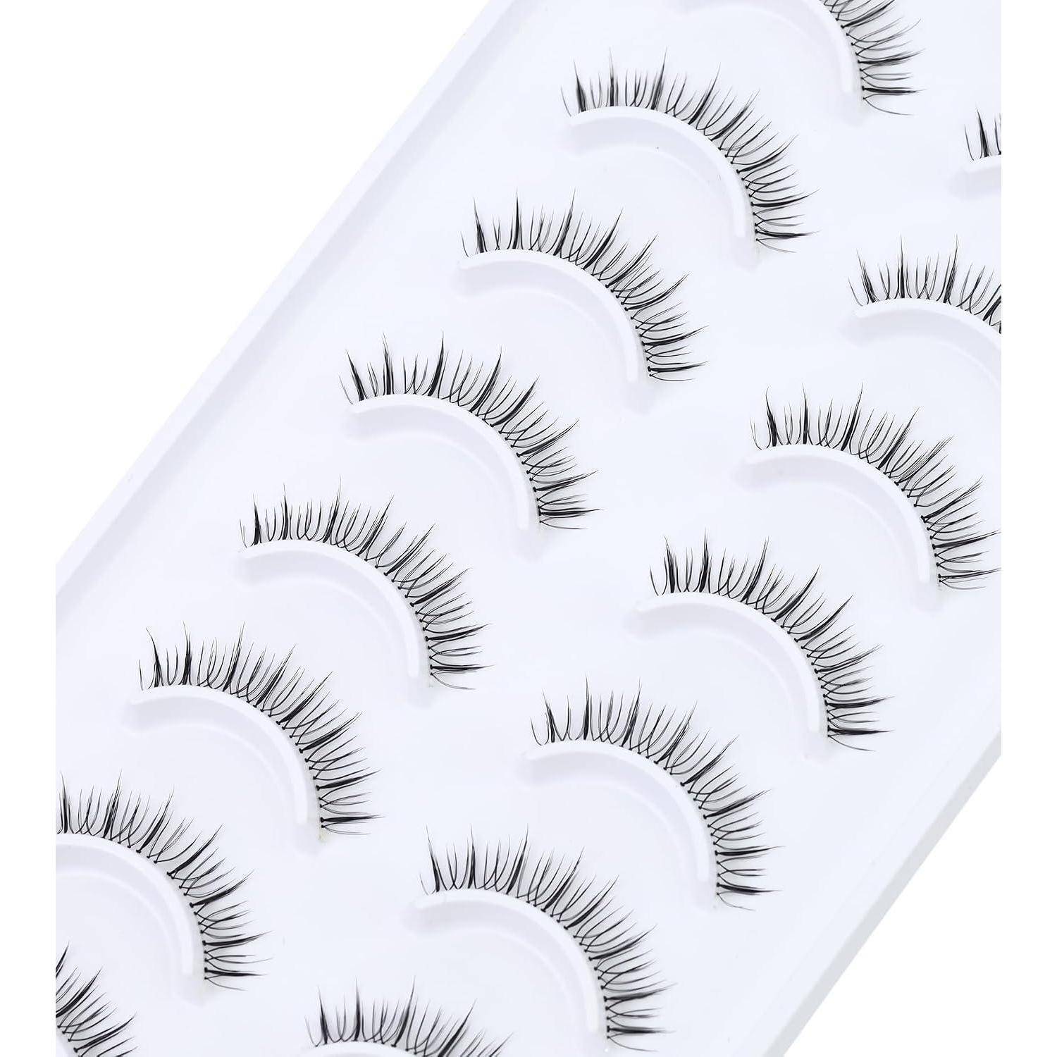 Packung mit falschen Wimpern in einem weißen Tablett angeordnet, zeigt mehrere Paare von langen, gekräuselten Wimpernstreifen.