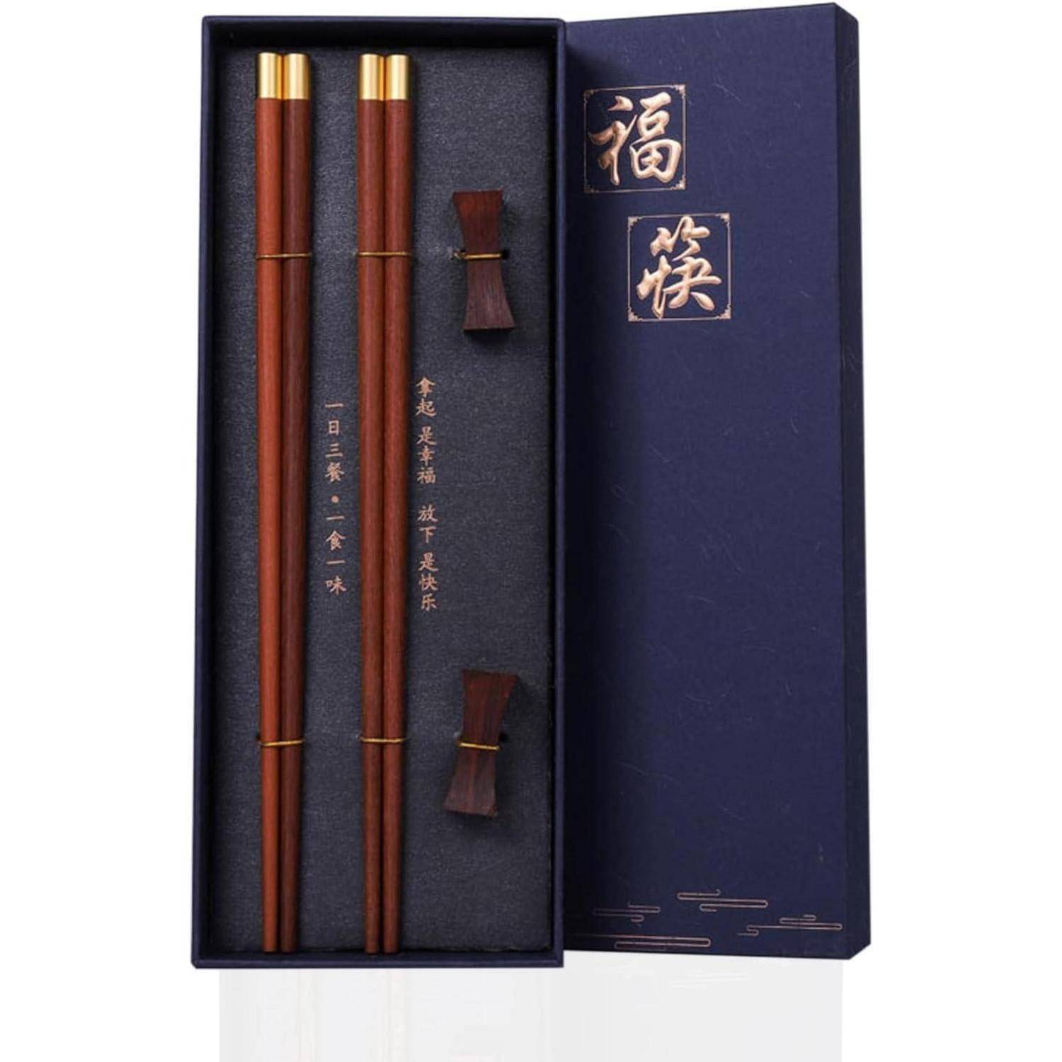 Präsentationsbox zum Öffnen mit zwei braunen Essstäbchen, zwei Ablagen und chinesischen Schriftzeichen auf dem Deckel