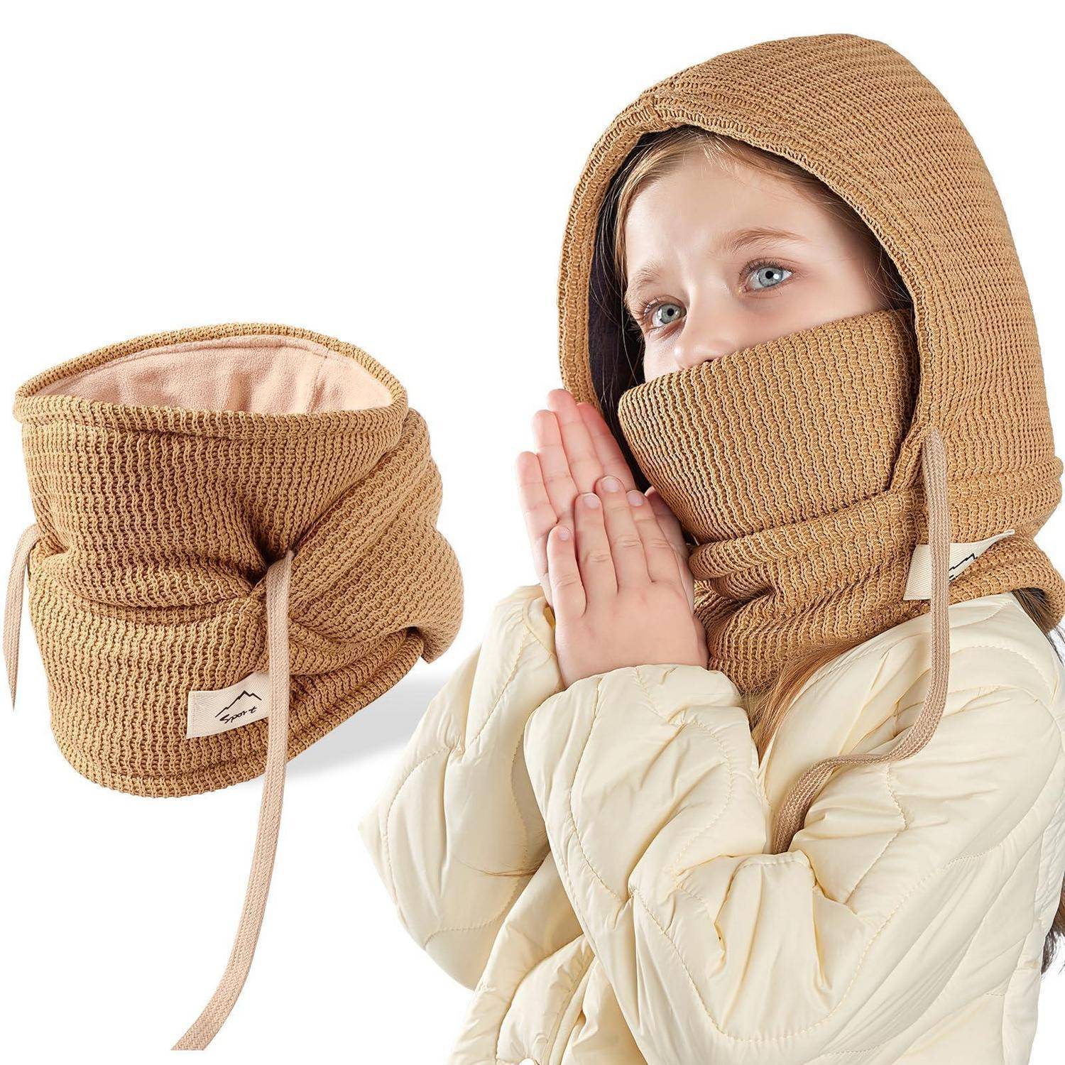 Kind, das eine beige Strickhaube mit Gesichtsmaske trägt, die Hände zusammen, als würde es sich aufwärmen; separate Ansicht der passenden Mütze, die neben dem Kind auf weißem Hintergrund gezeigt wird.