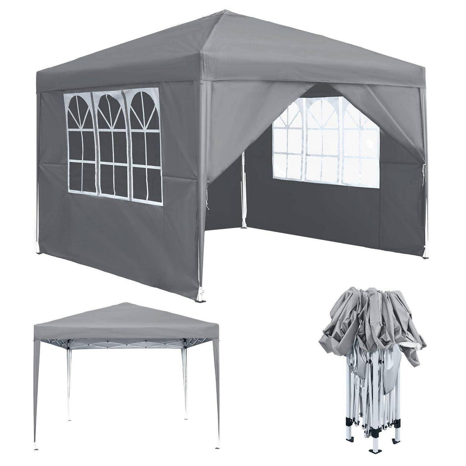 Graues Outdoor-Popup-Zelt mit gewölbten Fensterfeldern, teilweise zusammengebaut mit Rahmen und zusammengelegter Abdeckung darunter.