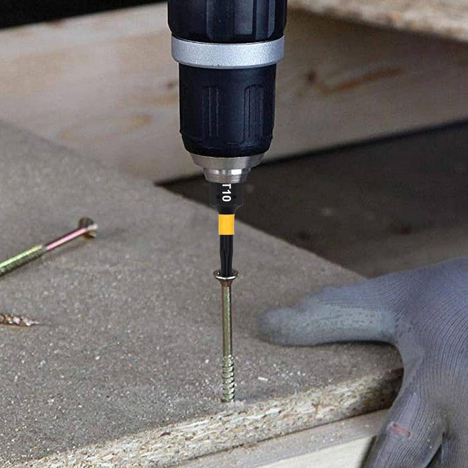 Elektrobohrer treibt eine Schraube in die Kante eines Bretts, während eine behandschuhte Hand das Material hält.