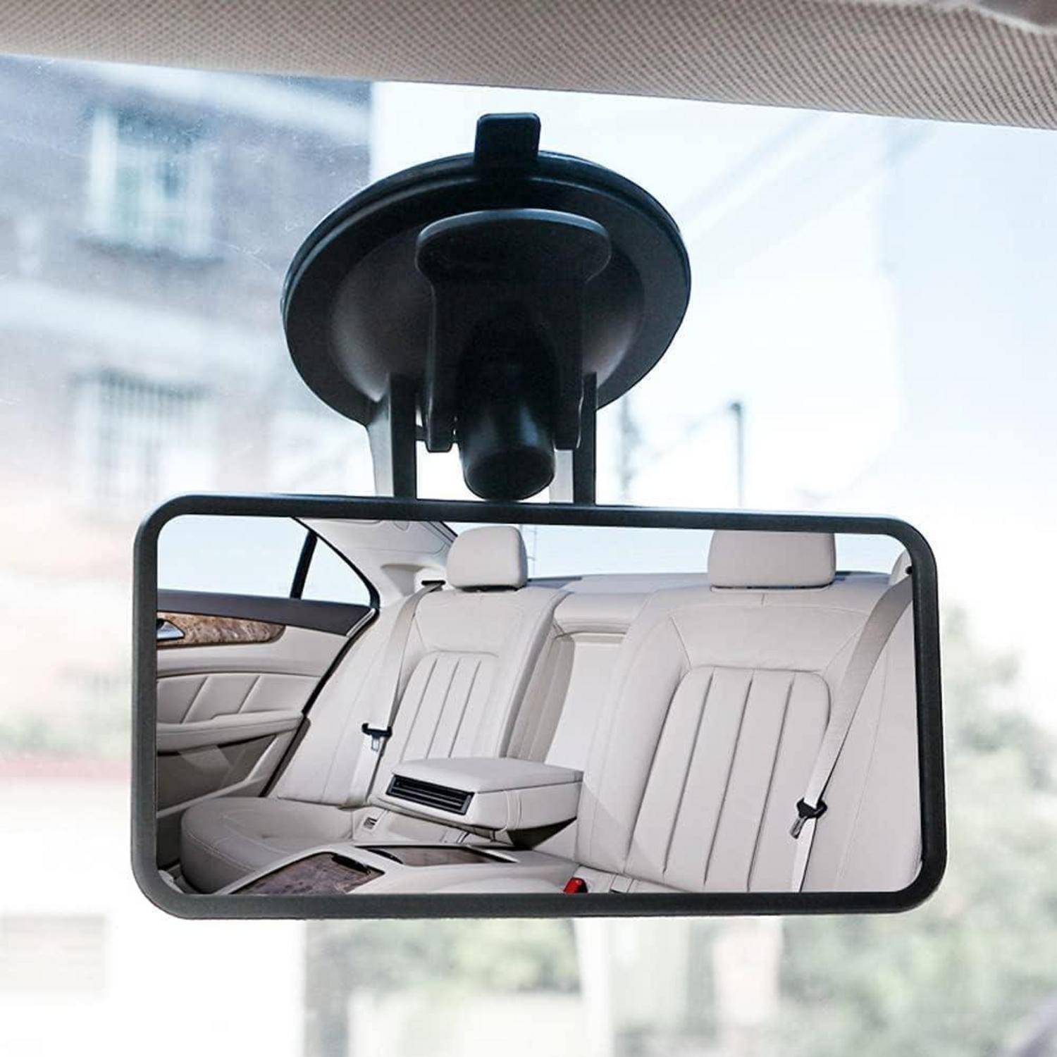 Rückspiegel, der die weiße Ledersitzbank und die mittlere Armlehne eines Autos widerspiegelt, an der Windschutzscheibe im Inneren des Fahrzeugs angebracht.