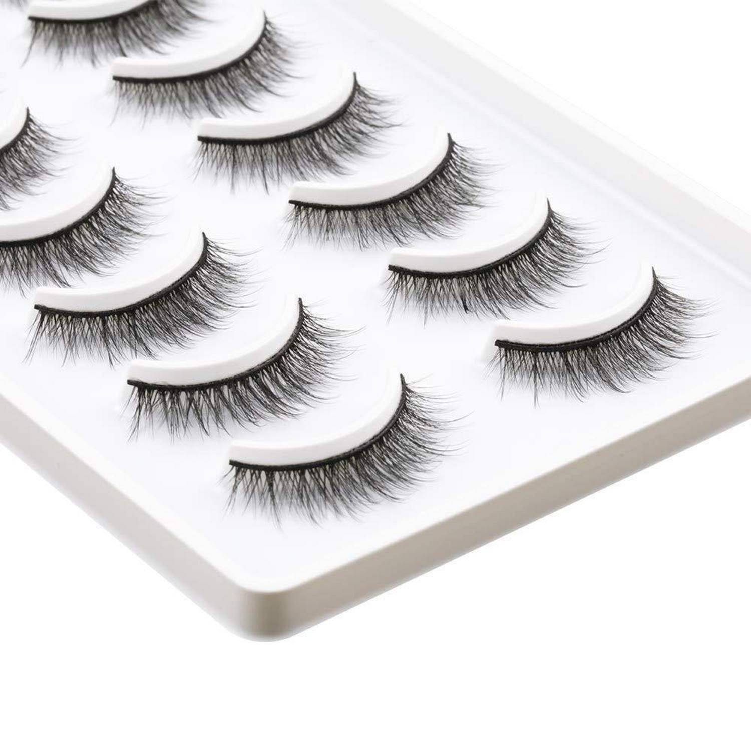 Verschiedene künstliche Wimpern auf einem weißen Tablett ausgestellt, mit mehreren Stilen in Reihen angeordnet.