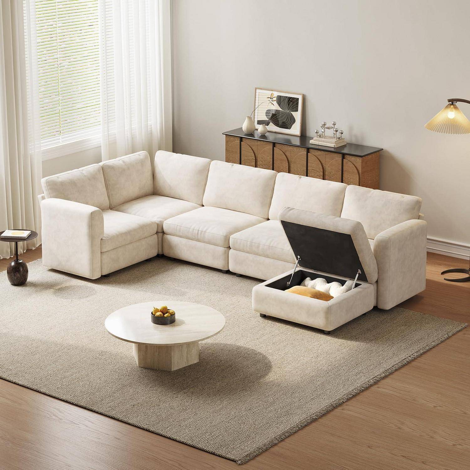 Cremefarbiges Ecksofa in einem minimalistischen Wohnzimmer, mit einem angehobenen Sitz, der verborgenen Stauraum offenbart.