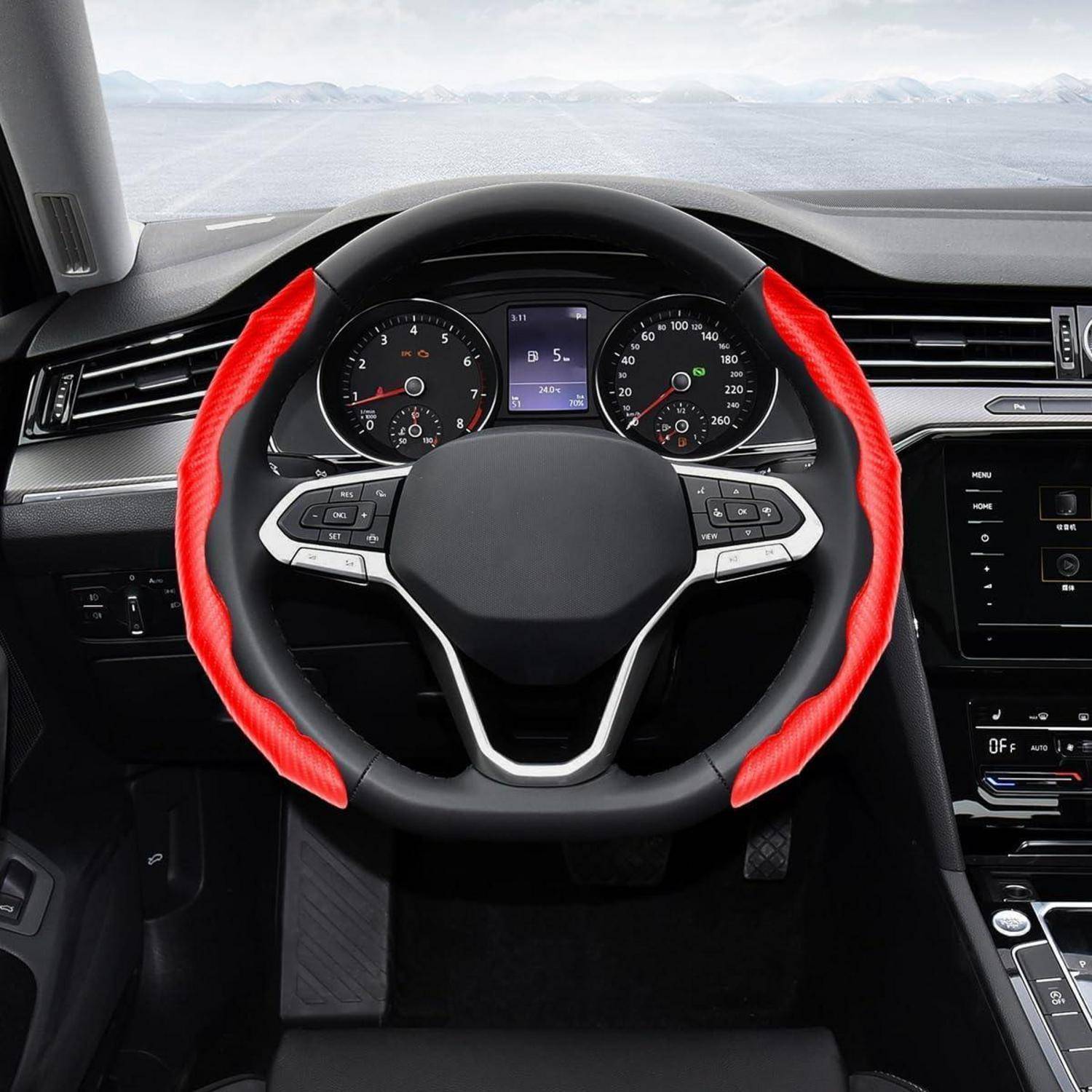 Blick vom Fahrersitz eines Autoinnenraums, der ein Lenkrad mit roten Griffbezügen, Armaturenbrettinstrumente, die mittlere Mittelkonsole und einen See oder das Meer vor der Windschutzscheibe zeigt.
