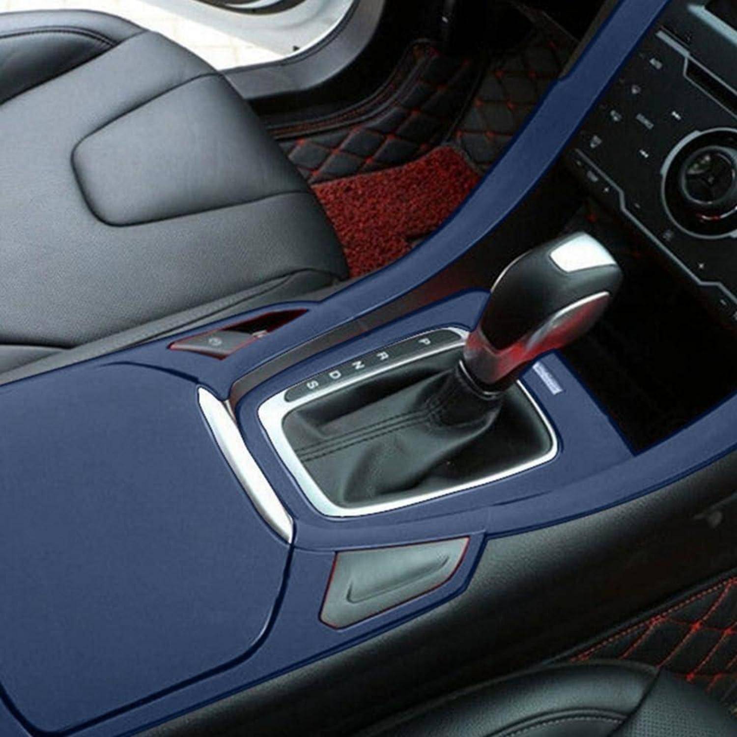 Nahaufnahme einer Mittelkonsole eines Autos mit einem Automatikschaltknüppel und umliegenden Verkleidungsteilen zwischen den Vordersitzen.