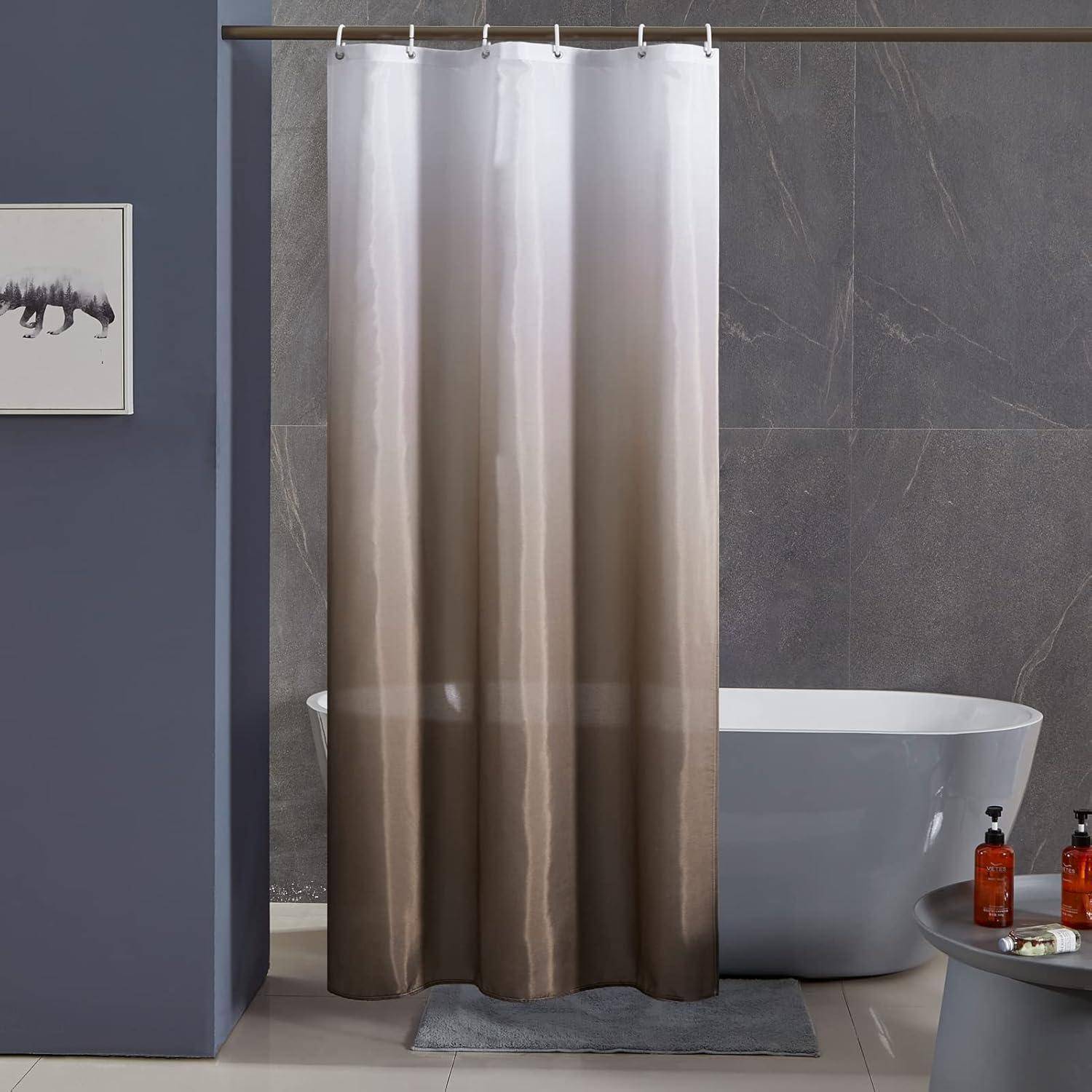 Modernes Badezimmer mit freistehender Badewanne hinter einem beigen Duschvorhang, grauen Fliesenwänden und einem kleinen Beistelltisch mit Flaschen.