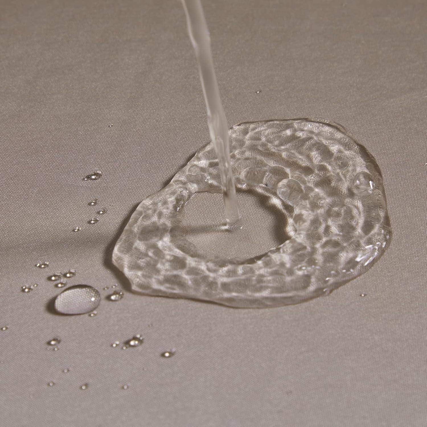 Wasser wird auf den Stoff gegossen, bildet eine kreisförmige Pfütze und zeigt die wasserabweisende Oberfläche des Materials.