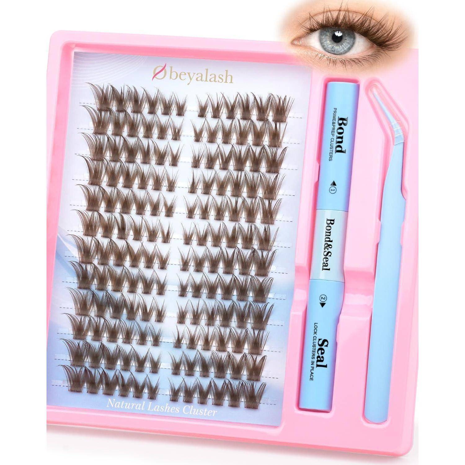 Kit für rosa Wimpernverlängerungen mit einem Tablett mit Cluster-Wimpern, Bond/Seal-Kleber-Applikator und Applikator-Pinzette; eine Augenvorschau erscheint in der Ecke.