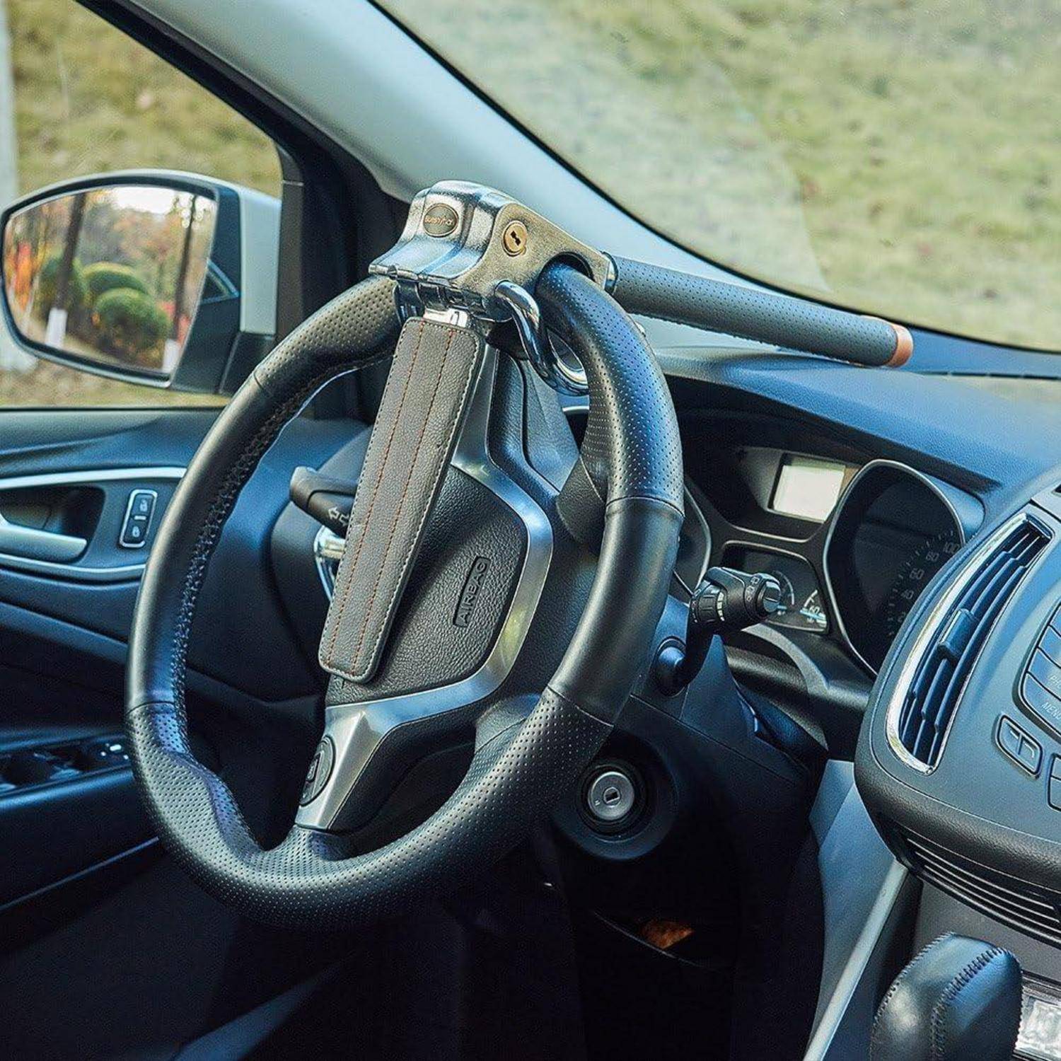 Ein Autolenkrad mit einer großen blau-schwarzen Handsteuervorrichtung, die adaptive Fahrtechnik für eine Person mit eingeschränkter Mobilität andeutet.