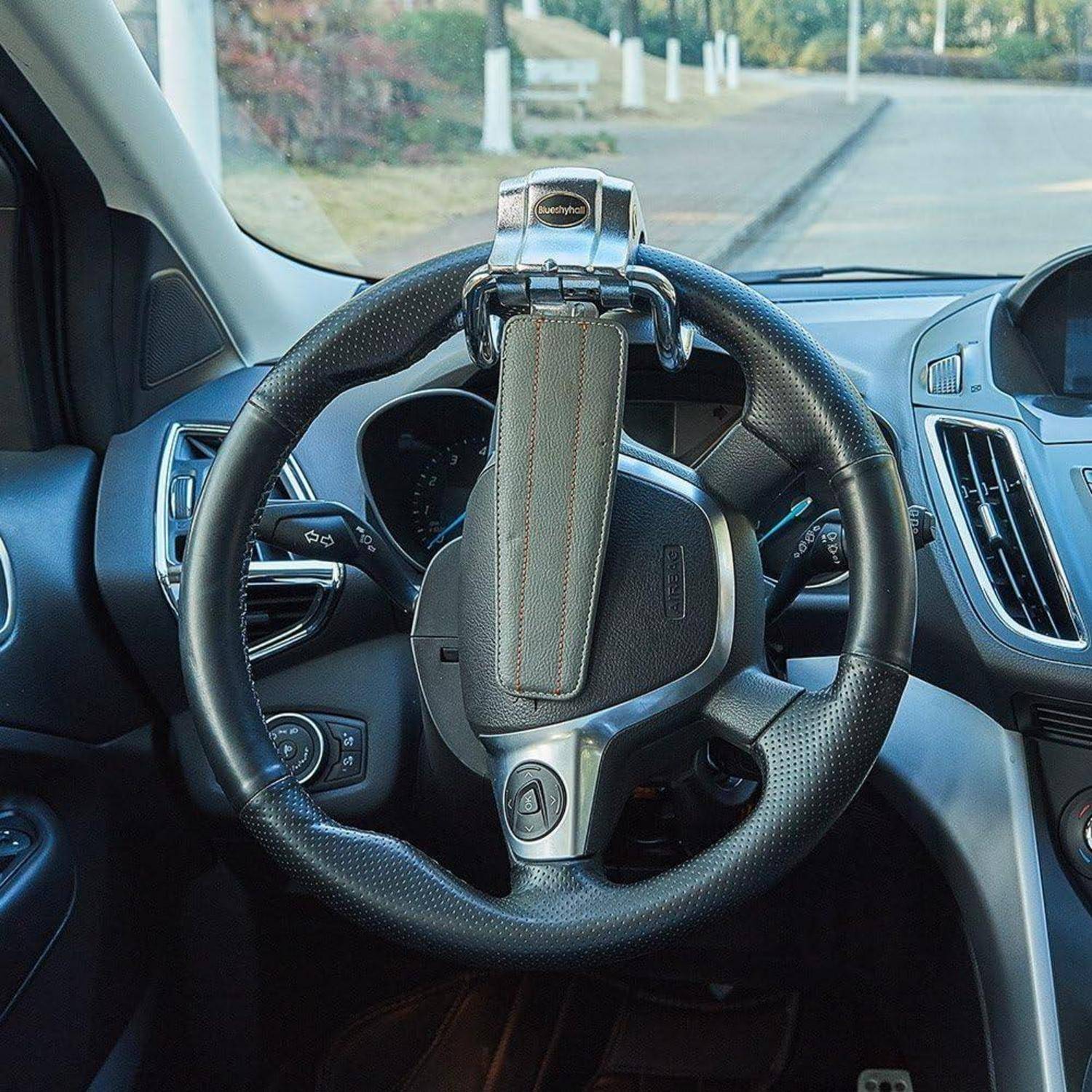 Lenkrad eines Autos mit einer angebrachten Telefonhalterung an der Oberseite, aus der Perspektive des Fahrers betrachtet.