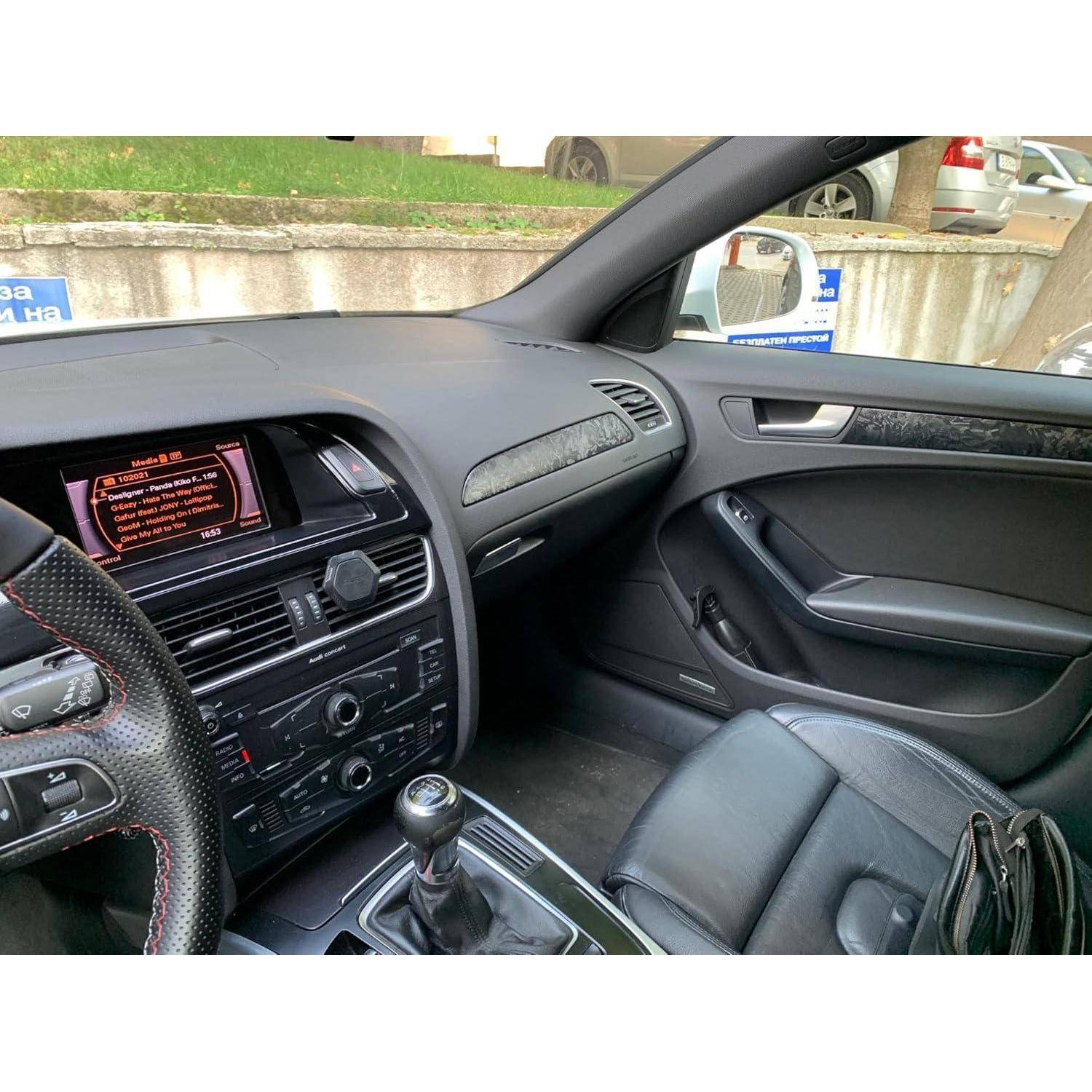 Autoinnenraum von der Beifahrerseite vorne, zeigt einen schwarzen Ledersitz, Armaturenbrett, Mittelkonsole, manueller Schaltknauf und Infotainment-Bildschirm.