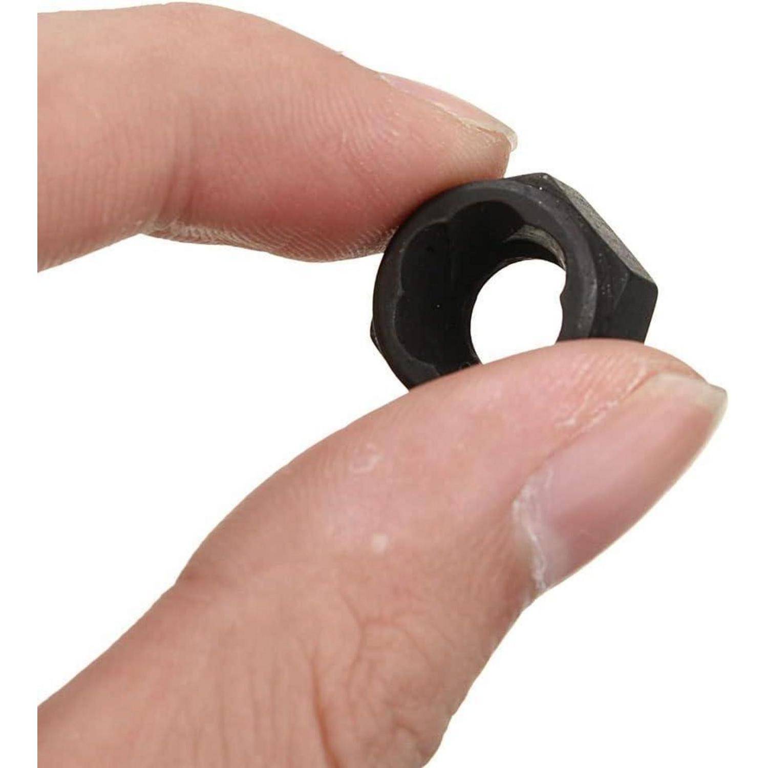 Nahaufnahme von Fingern, die eine kleine schwarze Sechskantmutter auf weißem Hintergrund halten.