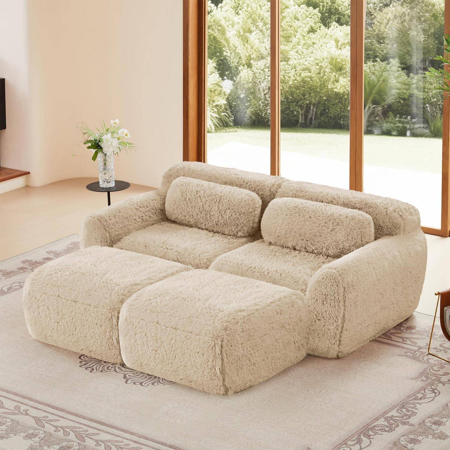 Flauschiges beiges modulares Sofa in einem hellen Wohnzimmer mit großen Fenstern und hellem Flächenteppich.