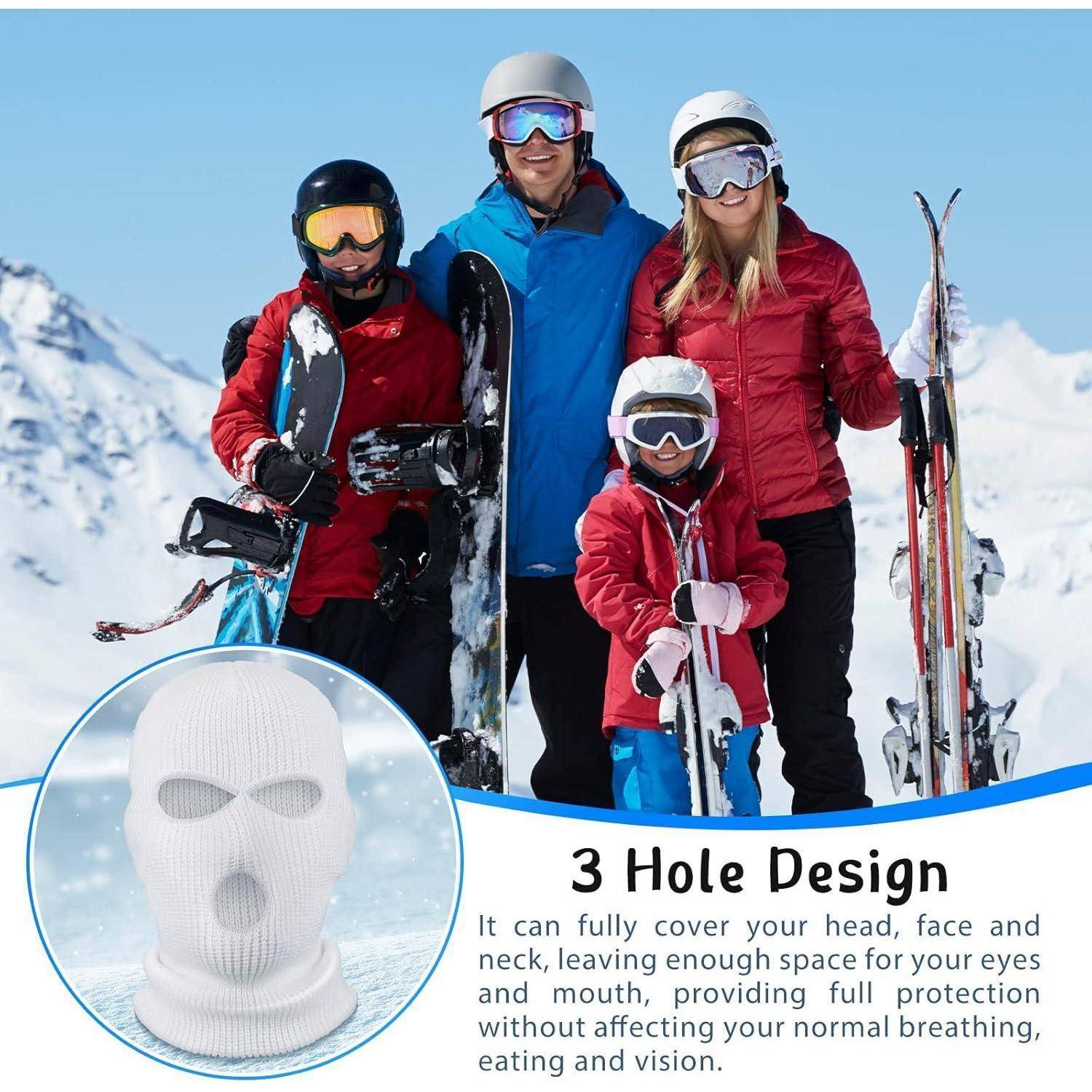 Familie zu viert in Skiausrüstung auf verschneiten Pisten, mit einer Vergrößerung, die eine weiße 3-Loch-Skimaske zeigt, und Text „3-Loch-Design", das vollständige Kopf-, Gesichts- und Halsbedeckung beschreibt.
