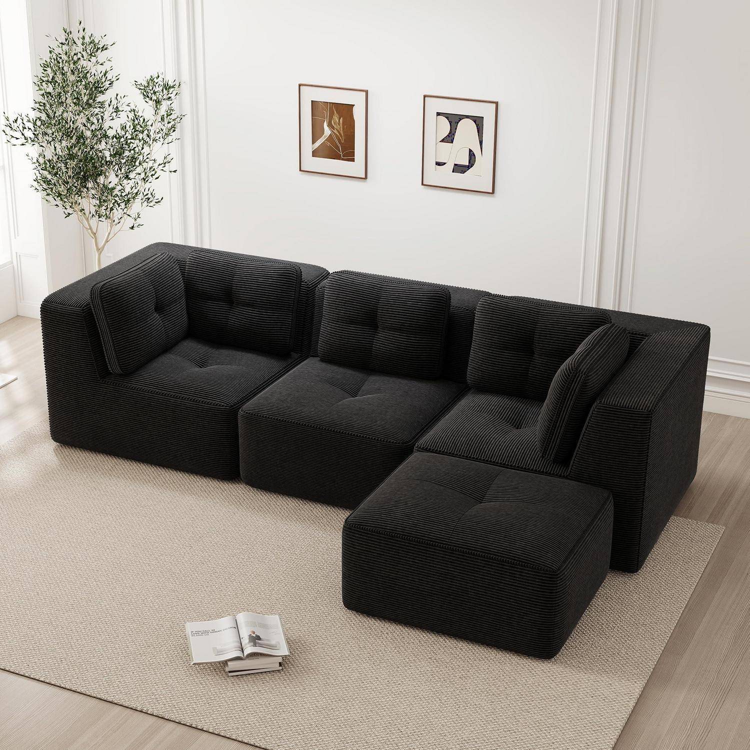 Schwarzes modulares Ecksofa mit Chaiselongue in einem minimalistischen Wohnzimmer auf einem beigen Teppich mit gerahmten Wandbildern, einer Pflanze und einer offenen Zeitschrift in der Nähe.
