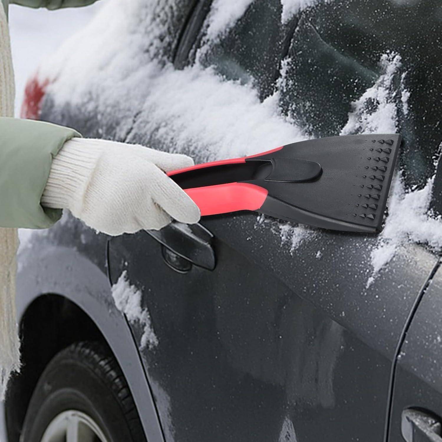 Behandschuhte Hand, die mit einem Kunststoffschaber Schnee von einem Autofenster und einer Autotür entfernt.