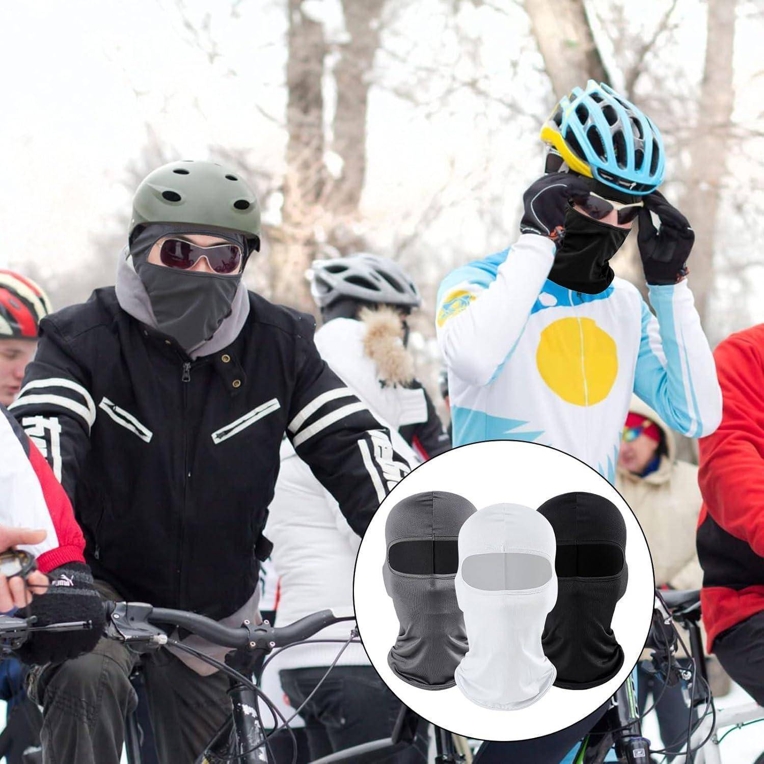 Radfahrer in Winterausrüstung mit Helmen, Schutzbrille und Gesichtsmasken bei einer Schneefahrt im Freien; die Einfügung zeigt drei Sturmhauben-Gesichtsabdeckungen in Schwarz, Weiß und Grau.