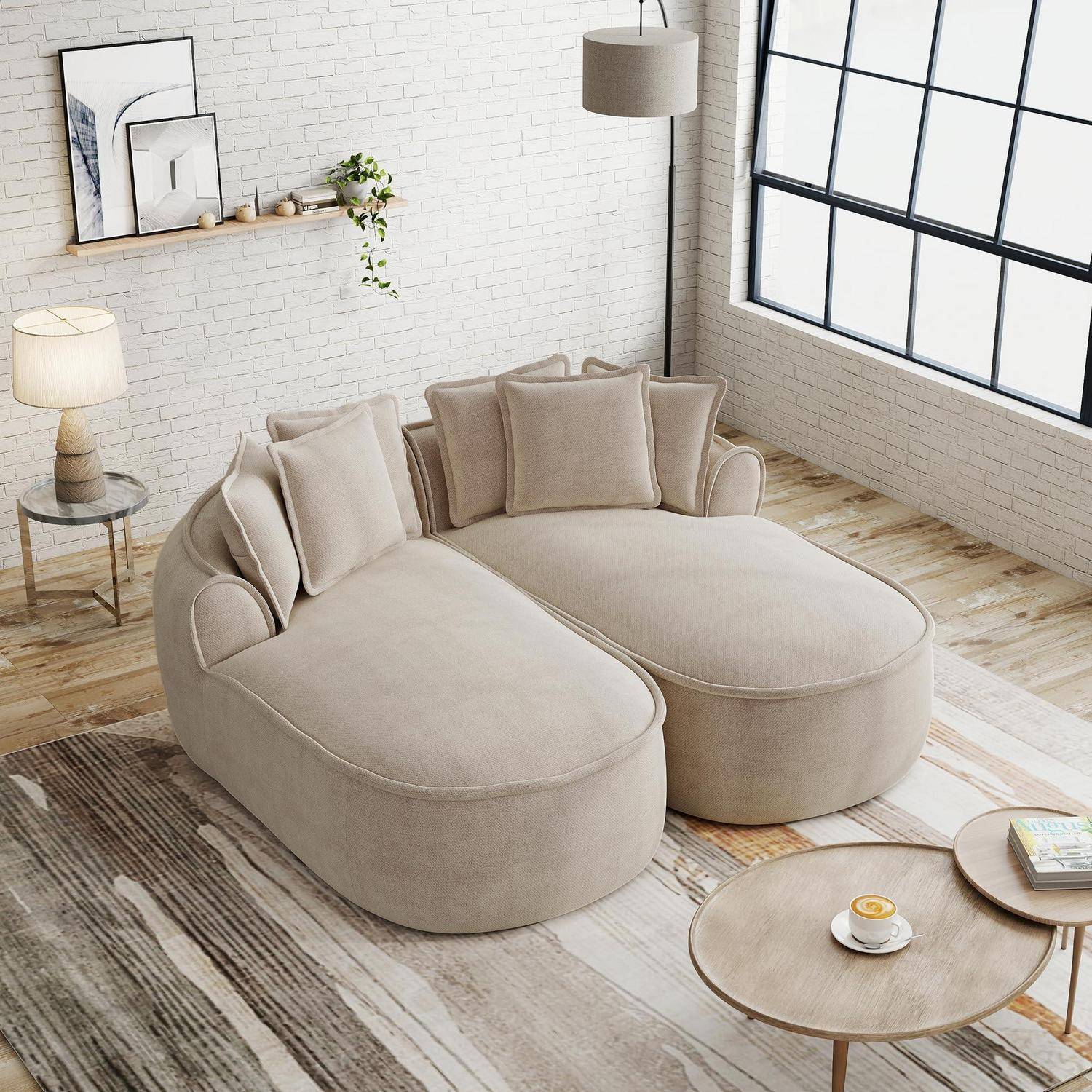 Beige U-förmiges modulares Sofa in einem hellen modernen Wohnzimmer mit großen Fenstern, weißen Backsteinmauern, Beistelltischen, Lampe und Wandkunst.