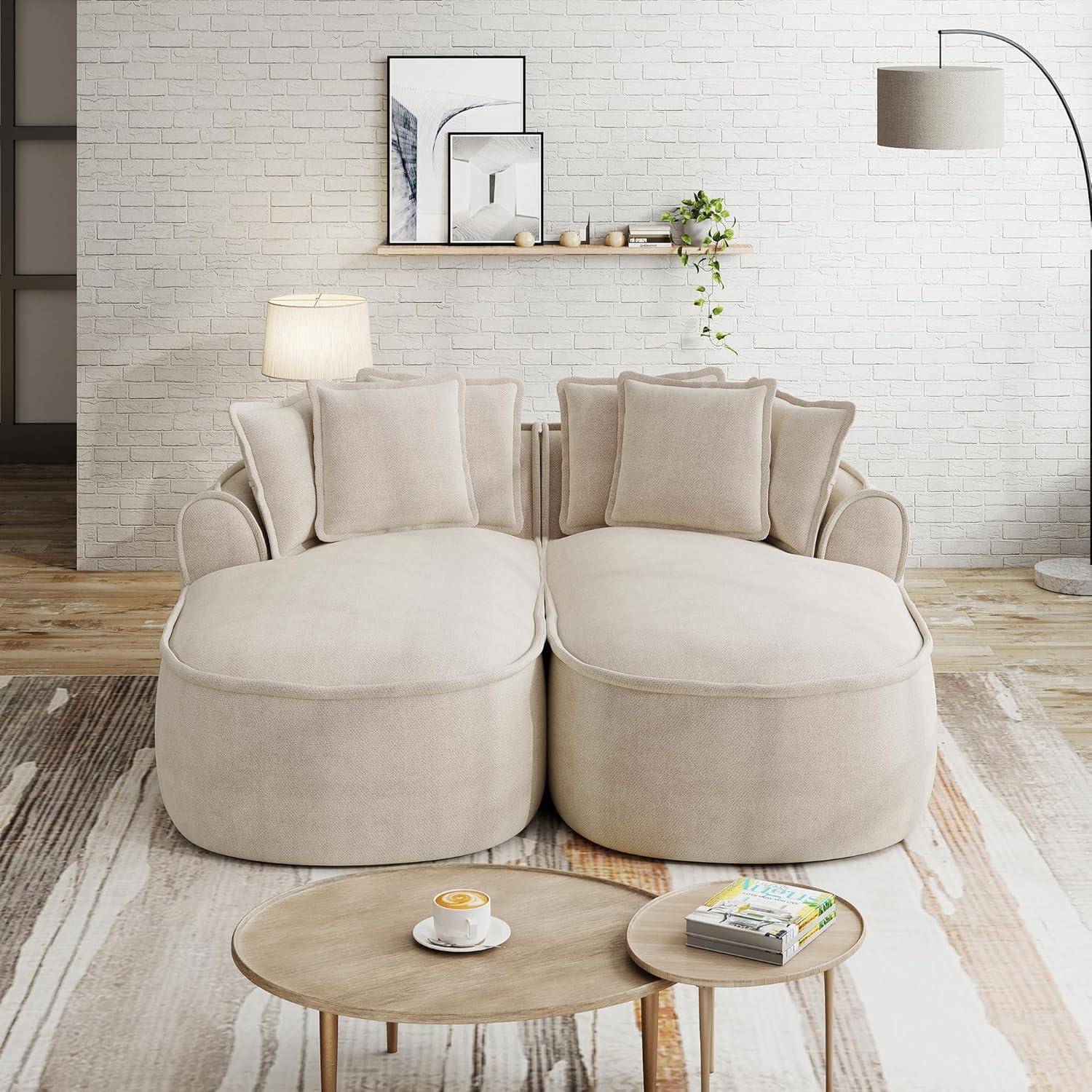 Modernes Wohnzimmer in Beige mit zwei übergroßen Chaiselonge-Sofas, runden verschachtelten Couchtischen, Stehleuchte, Wandregal und minimalistischer Dekoration.