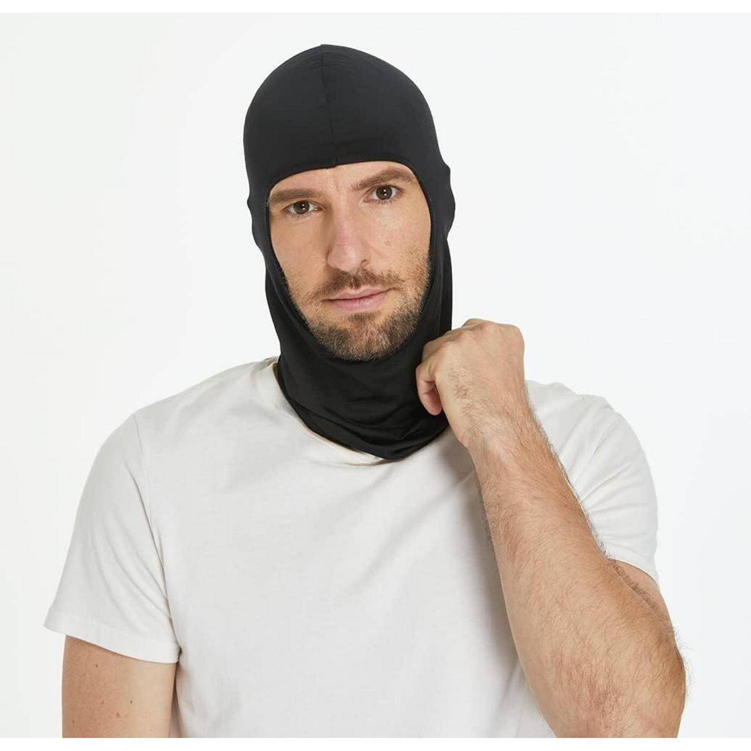 Mann mit schwarzer Sturmhaube und weißem T-Shirt, der den Stoff an seinem Hals vor einem einfachen weißen Hintergrund hält.