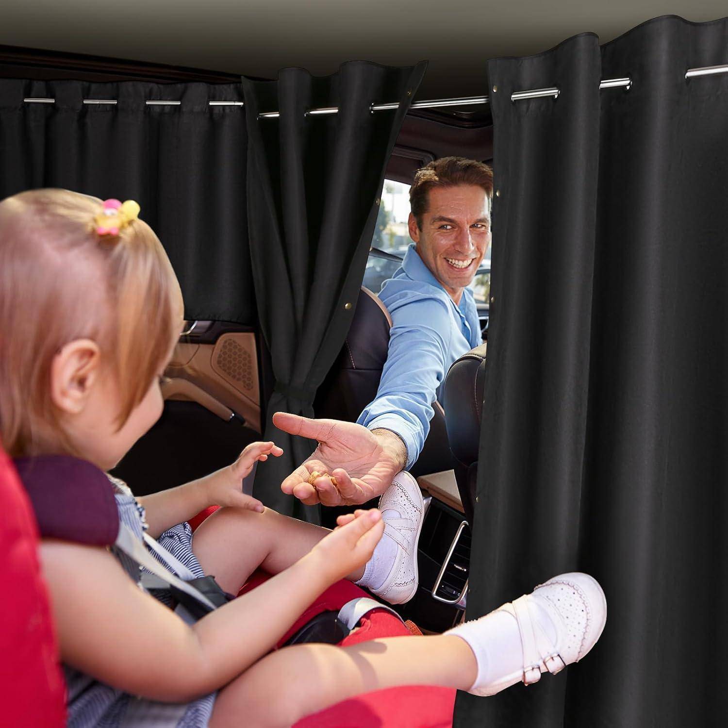 Ein Mann in einem Auto reicht einem Kind, das in einem Kindersitz hinter einem schwarzen Vorhang sitzt, ein kleines Objekt.