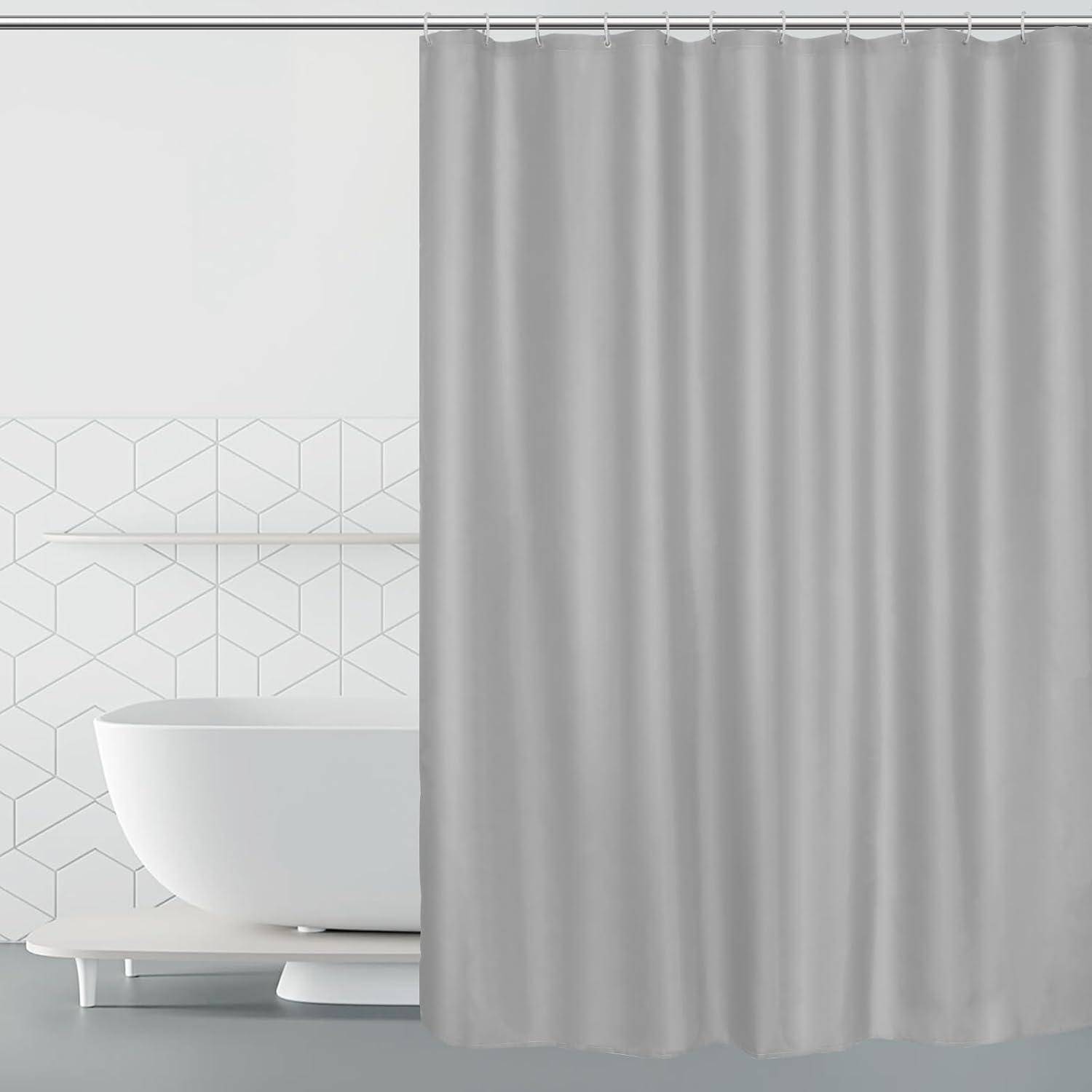 Weiße Badewanne teilweise verborgen hinter einem grauen Duschvorhang in einem hellen Badezimmer mit geometrisch gekachelter Wand.