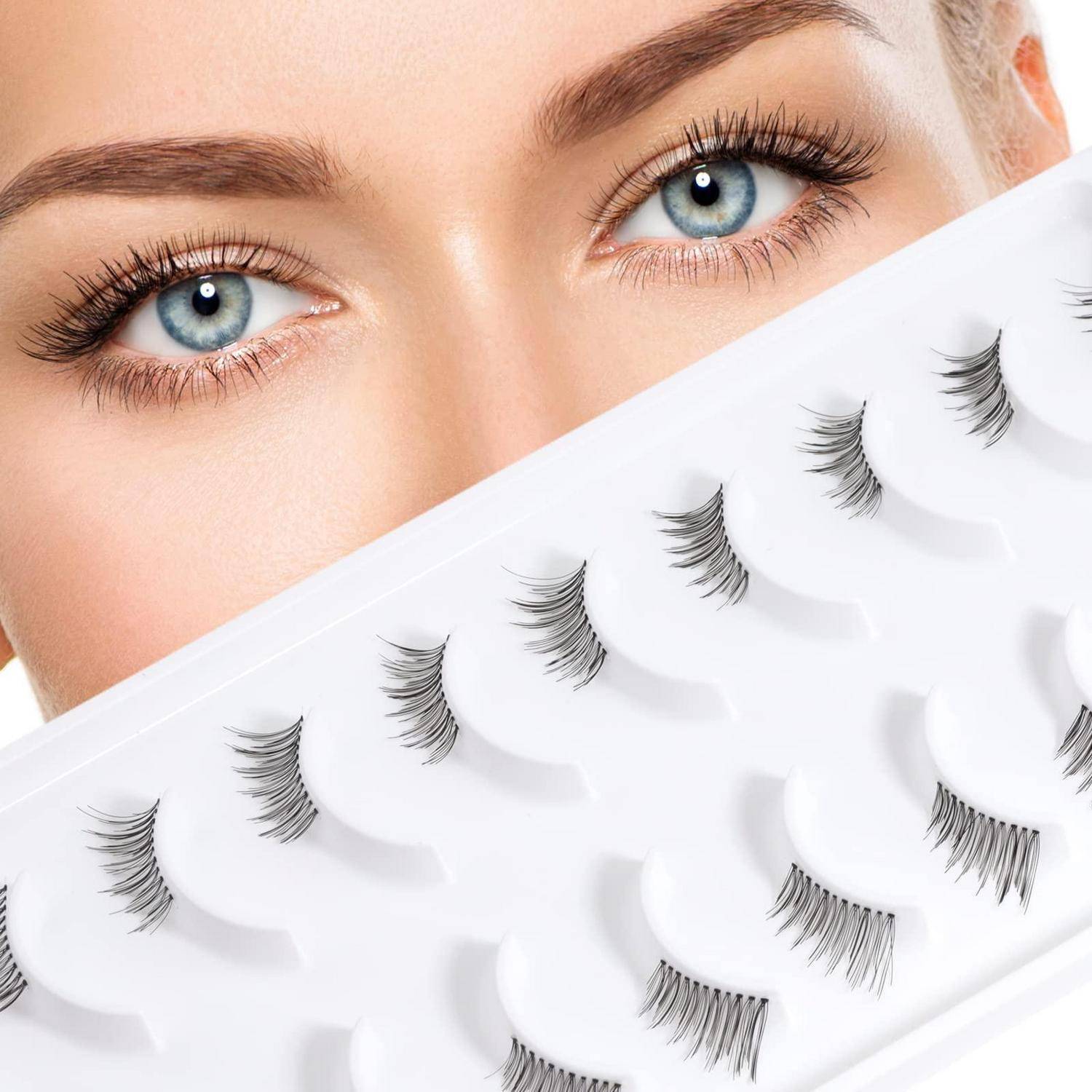 Nahaufnahme der blauen Augen einer Frau über einem Tablett mit künstlichen Wimpern, was auf Wimpernverlängerung oder Makeup-Auswahl hindeutet.