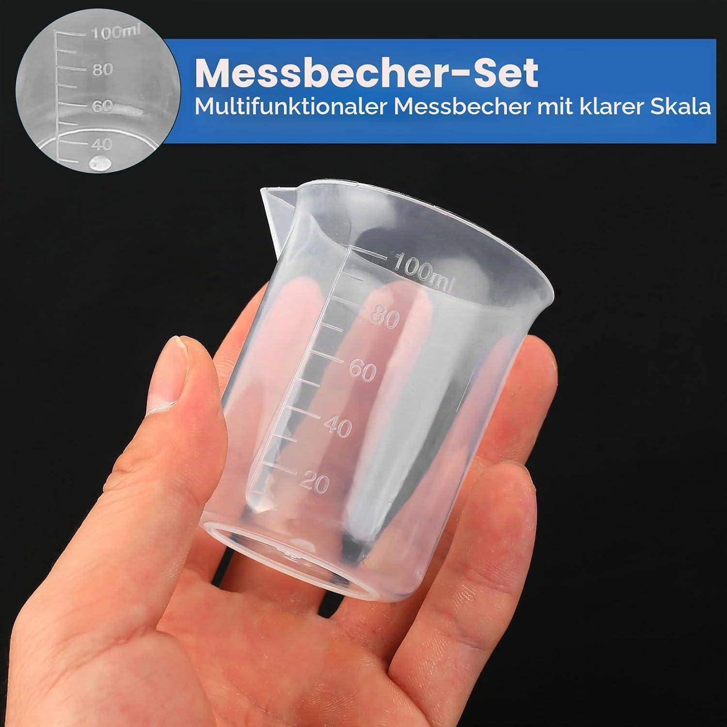 Hand hält einen klaren 100-ml-Messbechersatz mit Graduierungsskala; die Produkttext sagt „Messbecher-Set" und „Multifunktionaler Messbecher mit klarer Skala"".