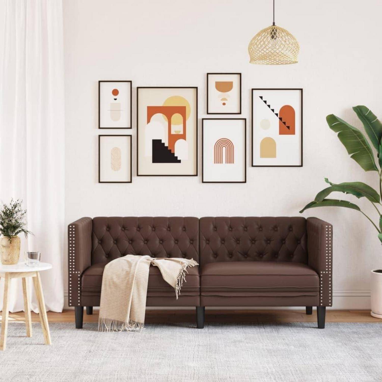 Modernes Wohnzimmer mit braunem Chesterfield-Sofa, gerahmtem abstrakter Wandgemälde, hängender Pendelleuchte, Beistelltisch und großer Topfpflanze