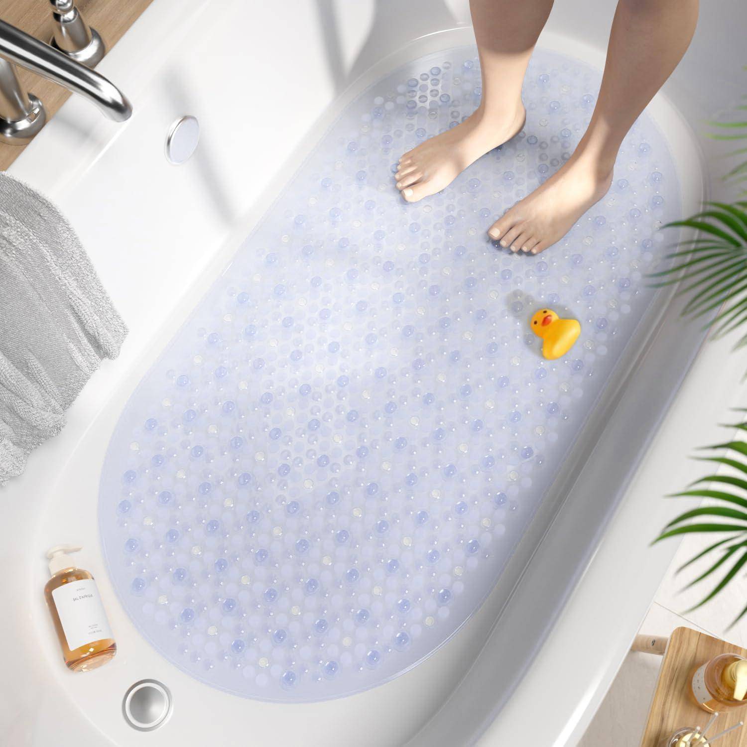 Person standing in a bathtub gefüllt mit klaren Badperlen, mit einer Gummienten und Toilettenartikel in der Nähe.