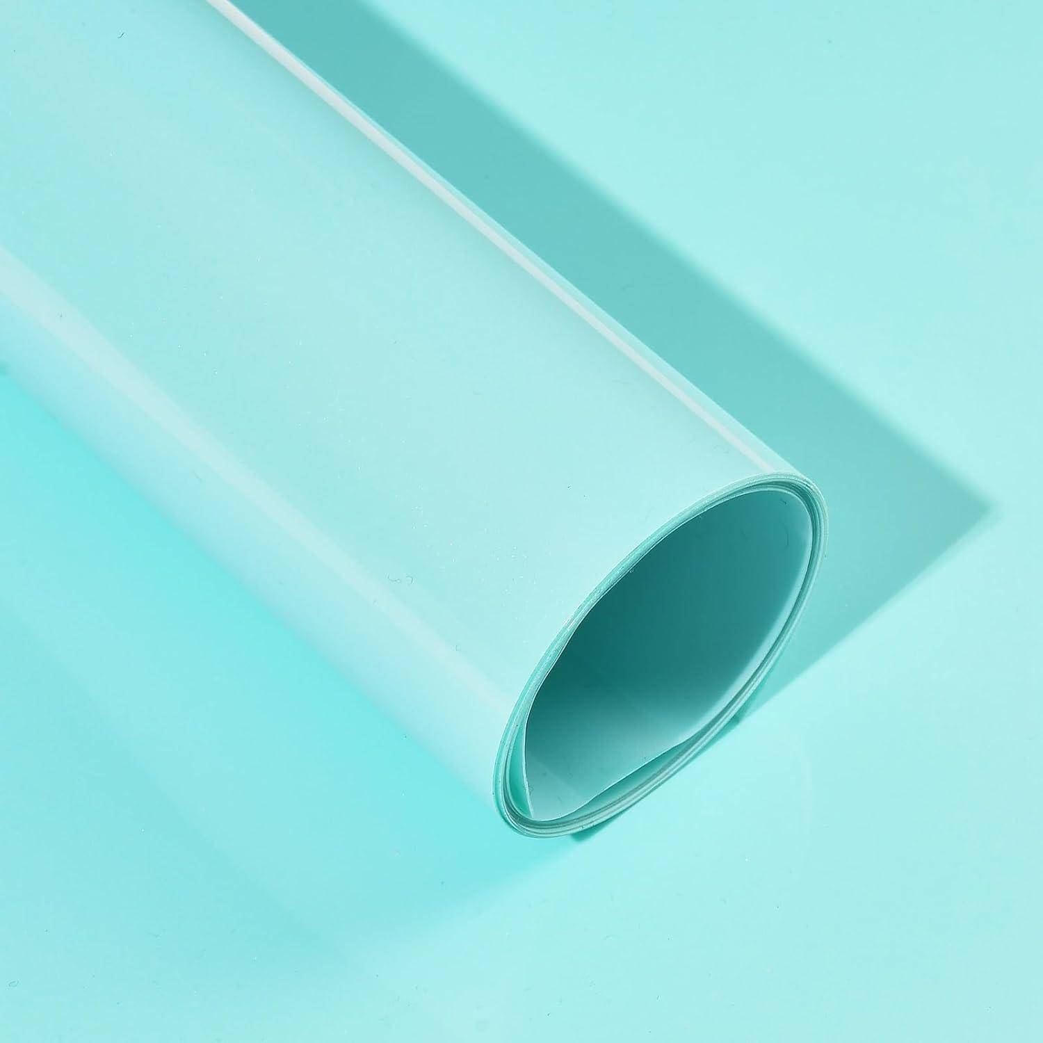 Eine aufgerollte Bahn aus durchscheinendem, aquafarbenem Kunststoff oder Vinyl auf hellblauem Hintergrund.