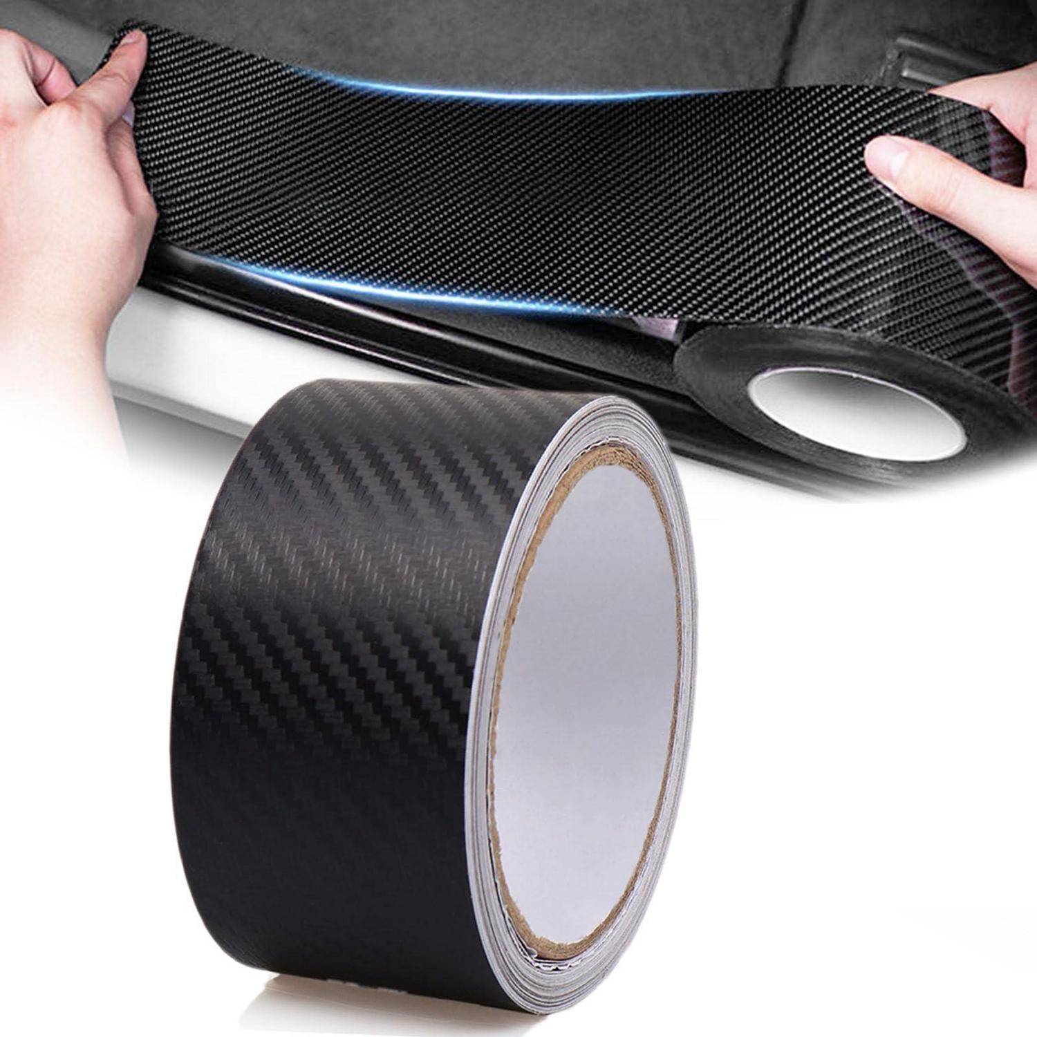 Rolle aus schwarzem Kohlefaser-Vinyl-Wrap, die auf ein Auto-Zierleistenteil angebracht wird, mit sichtbarem Klebstofffilm und glänzendem Finish.