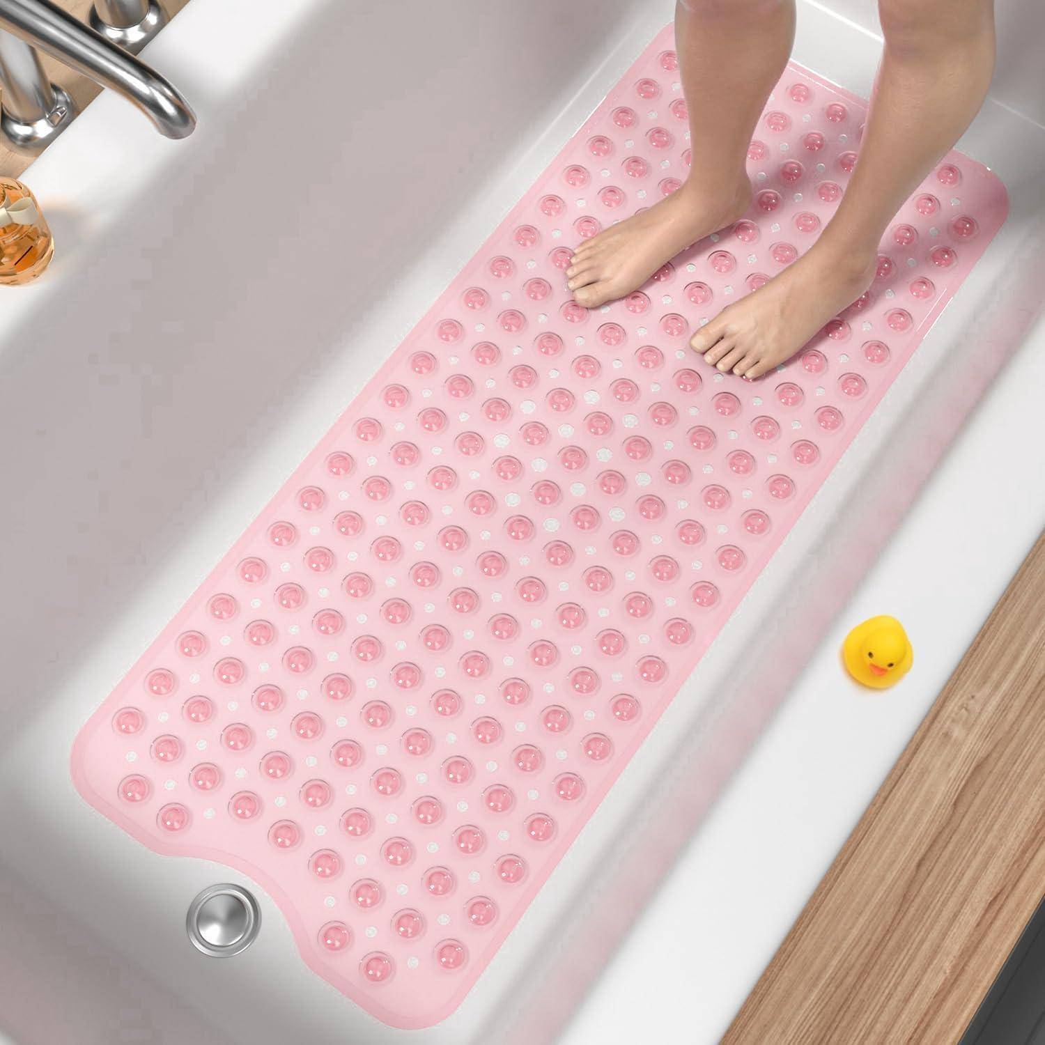 Füße stehen auf einer rosa Saugnapf-Badematte in einer Badewanne, mit einem Abfluss und einer kleinen gelben Ente in der Nähe.