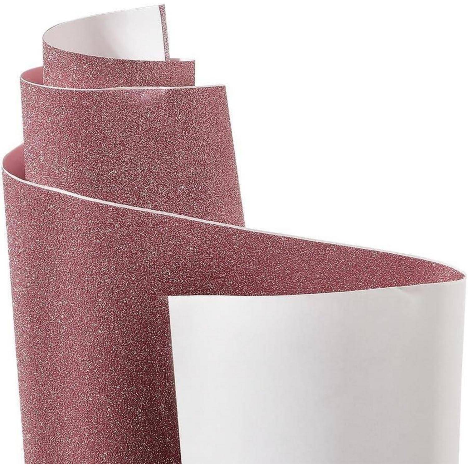Gerolltes Blatt rosa Glittergleitpapier, zu einer Schleife gekrümmt auf weißem Hintergrund.