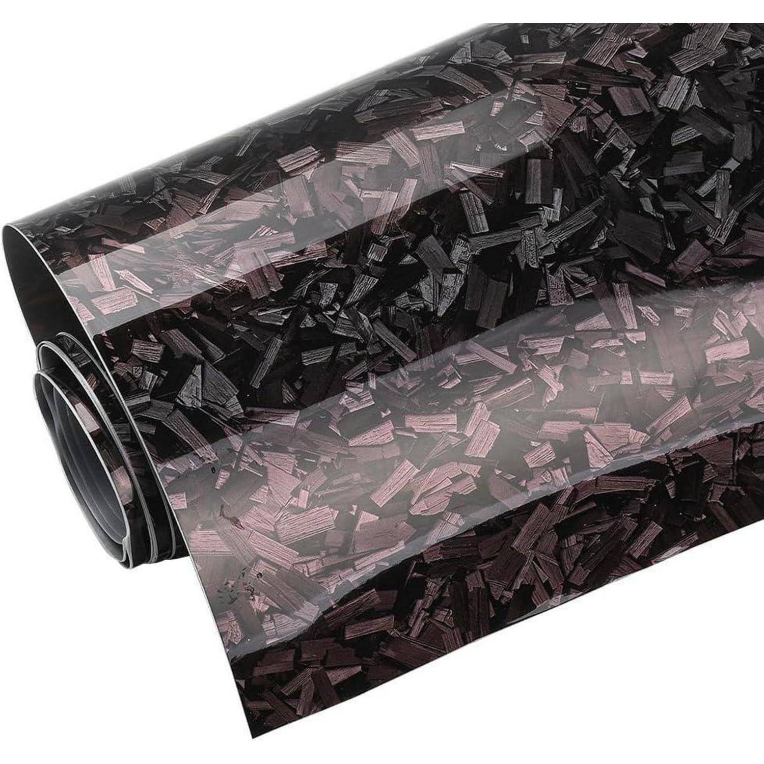 Aufgerollte Folie aus transparentem dekorativem Material mit einem schwarz-rosa Mosaikmuster auf weißem Untergrund.