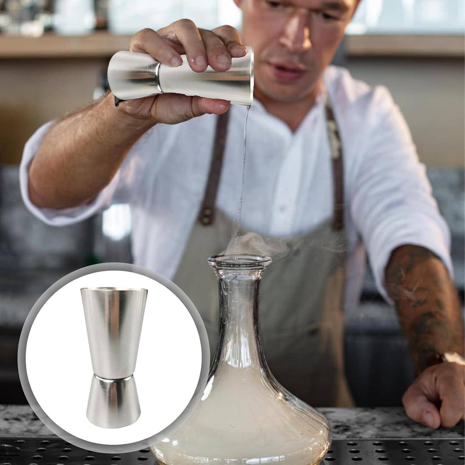 Barkeeper gießt ein Getränk aus einem Metallmessbechern in eine Glaskanne, mit einer Vergrößerung, die den Messbechner zeigt.