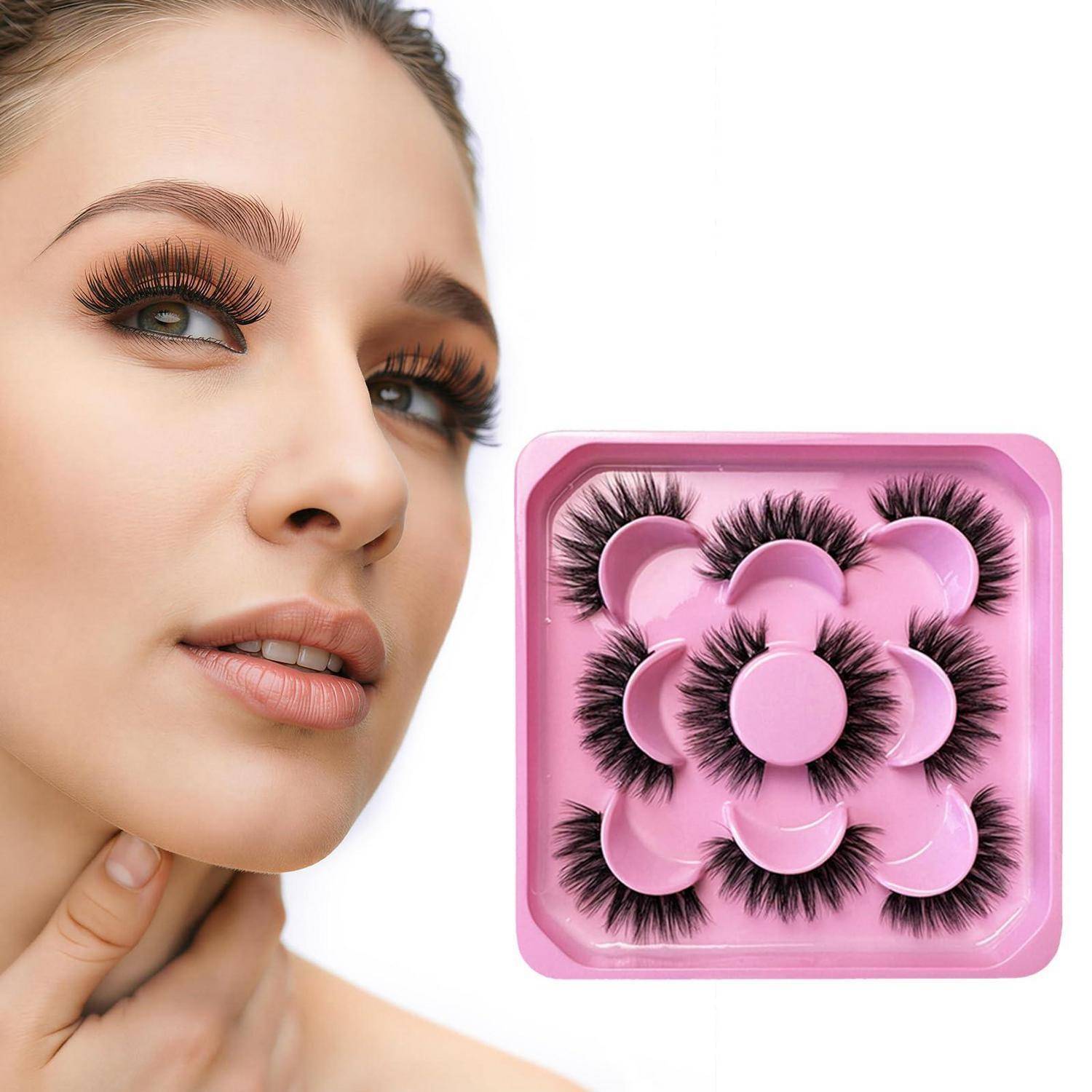 Nahaufnahme einer Frau mit dramatischen künstlichen Wimpern neben einem rosa Tablett mit Paaren von künstlichen Wimpern.