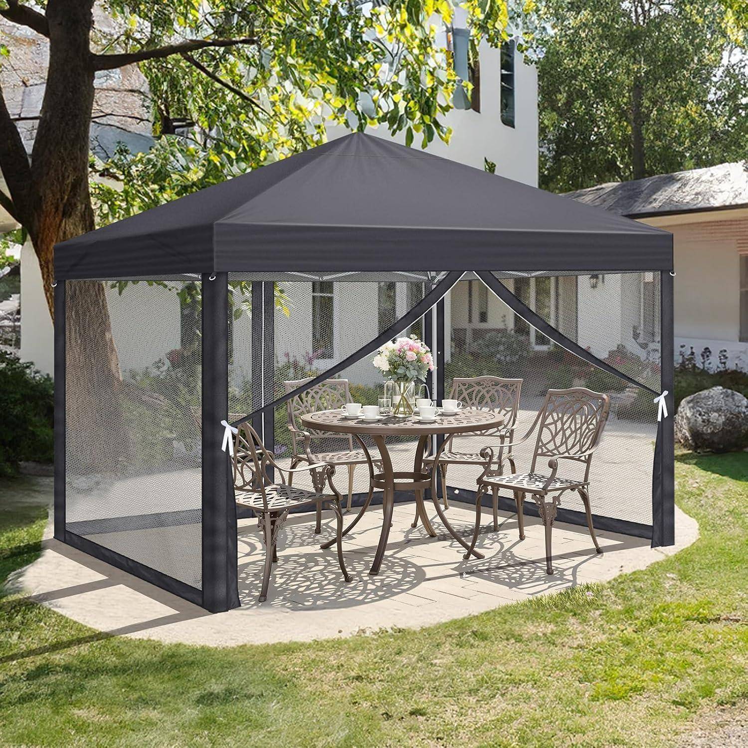 Schwarzes Maschengewebe-Pavillon-Vordach über einem Terrassentisch mit vier Stühlen im Hinterhof, das Schatten für Außenmahlzeiten und Insektenschutz bietet.