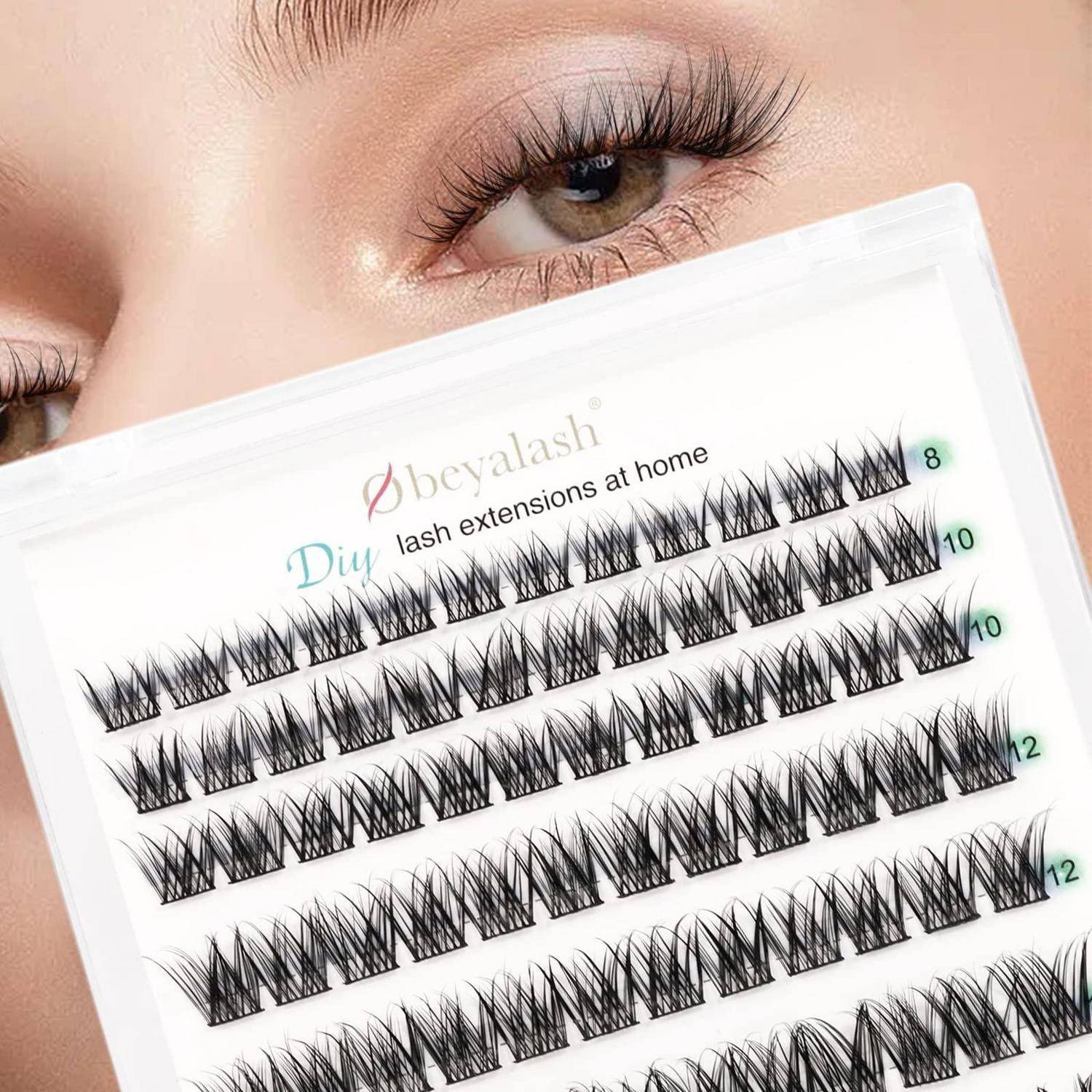 Eine Person hält eine Schachtel mit DIY-Wimpernverlängerungen zu Hause hoch und zeigt mehrere Reihen von künstlichen Wimpernbüscheln mit beschrifteten Längen von 8, 10 und 12.