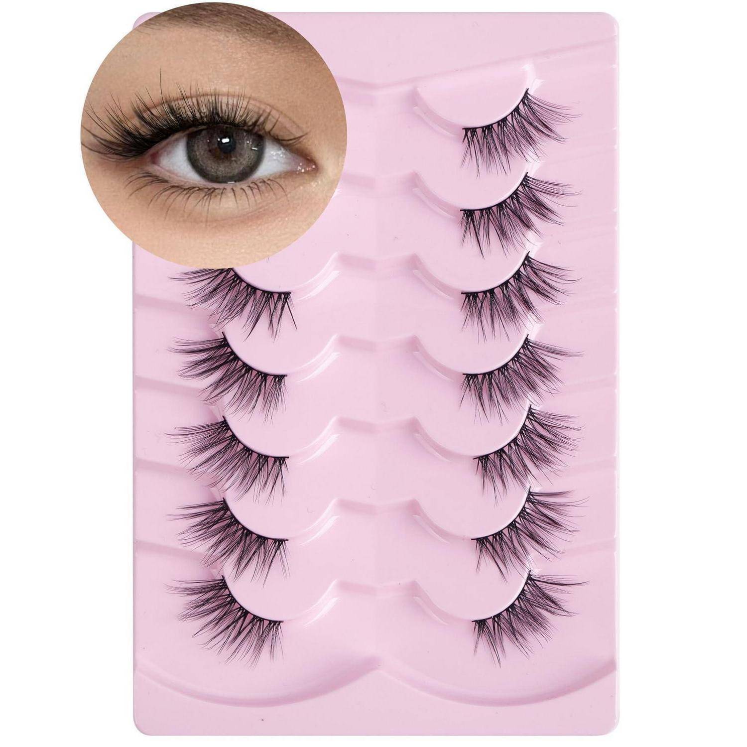 Rosa Tablett mit fünf Paar künstlichen Wimpern mit einer vergrößerten Nahaufnahme eines natürlichen Auges mit Wimpern.