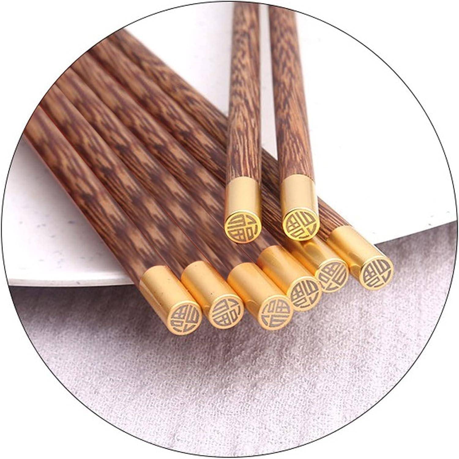 Nahaufnahme von dekorativen Holzstäbchen mit goldfarbenen Enden und eingraviertem chinesischem Stil-Logo, fächerartig auf einer weißen Oberfläche angeordnet.