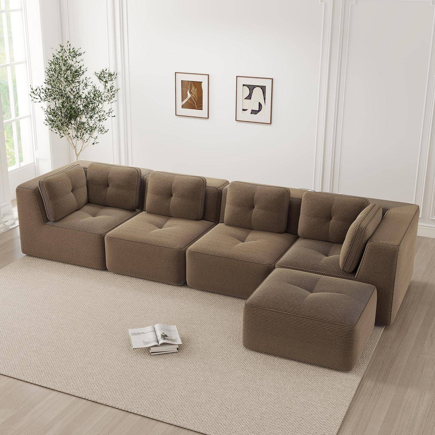 Braunes modulares Sofa mit passendem Ottoman in einem hellen minimalistischen Wohnzimmer, auf einem großen beigen Teppich mit Wandkunst und einer Pflanze.