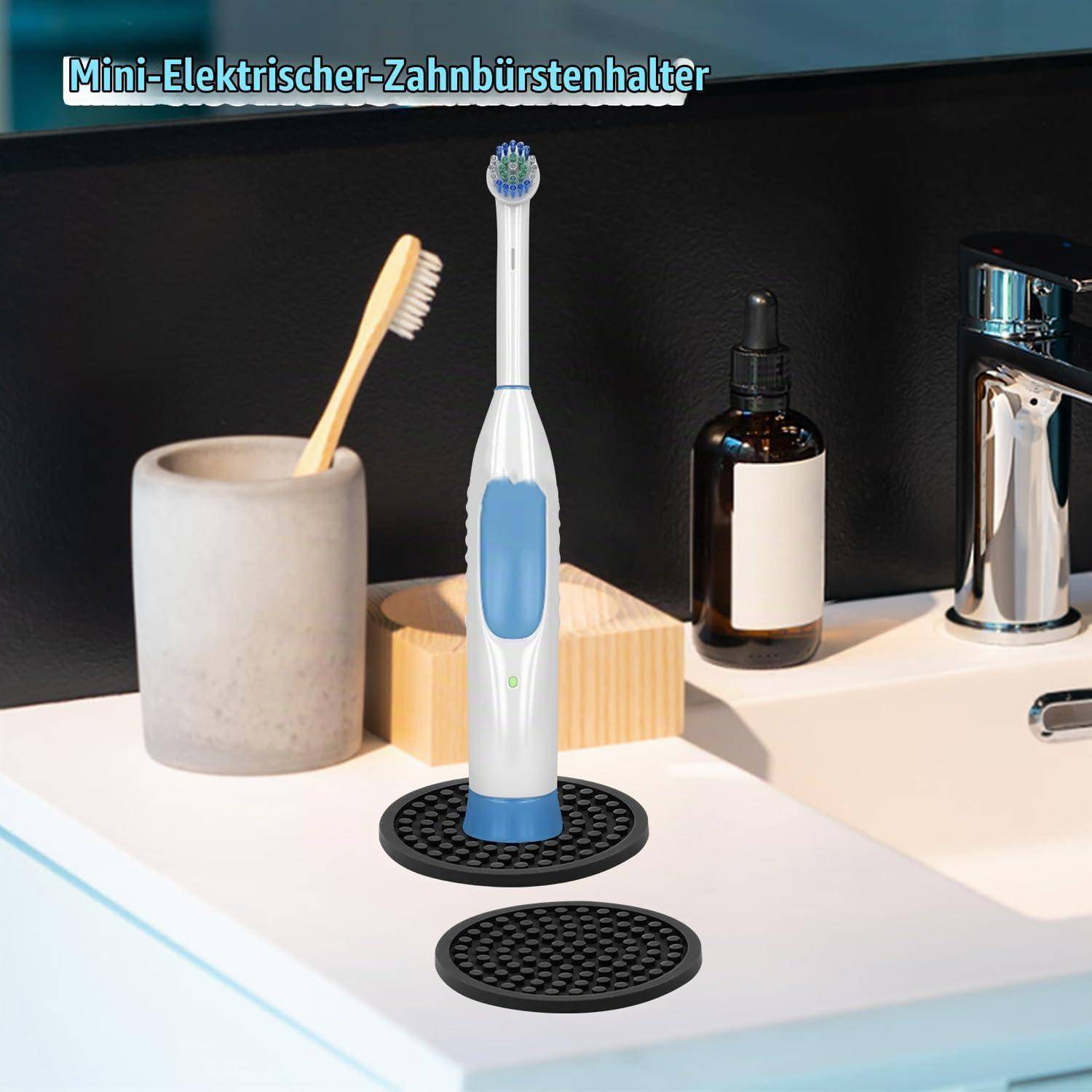 Elektrische Zahnbürstenhalter im Badezimmer auf der Waschtischplatte, mit einer Zahnbürste, die auf einem schwarzen Sockel steht, und deutschem Text „Mini-Elektrischer-Zahnbürstenhalter